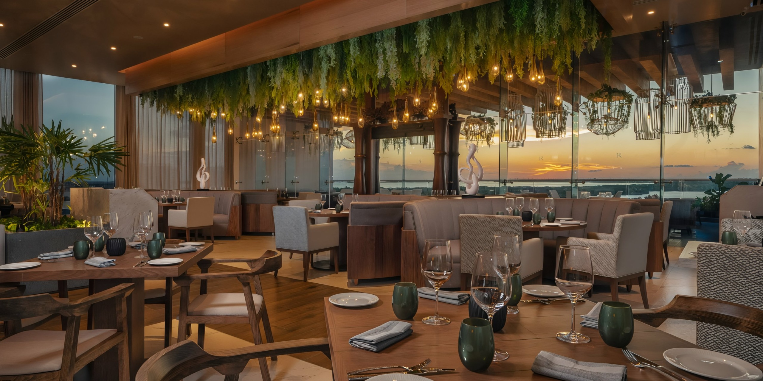 Luxurious Hilton Cancun Mar Caribe interior at sunset, featuring elegant dining setup with panoramic view of the skyline.