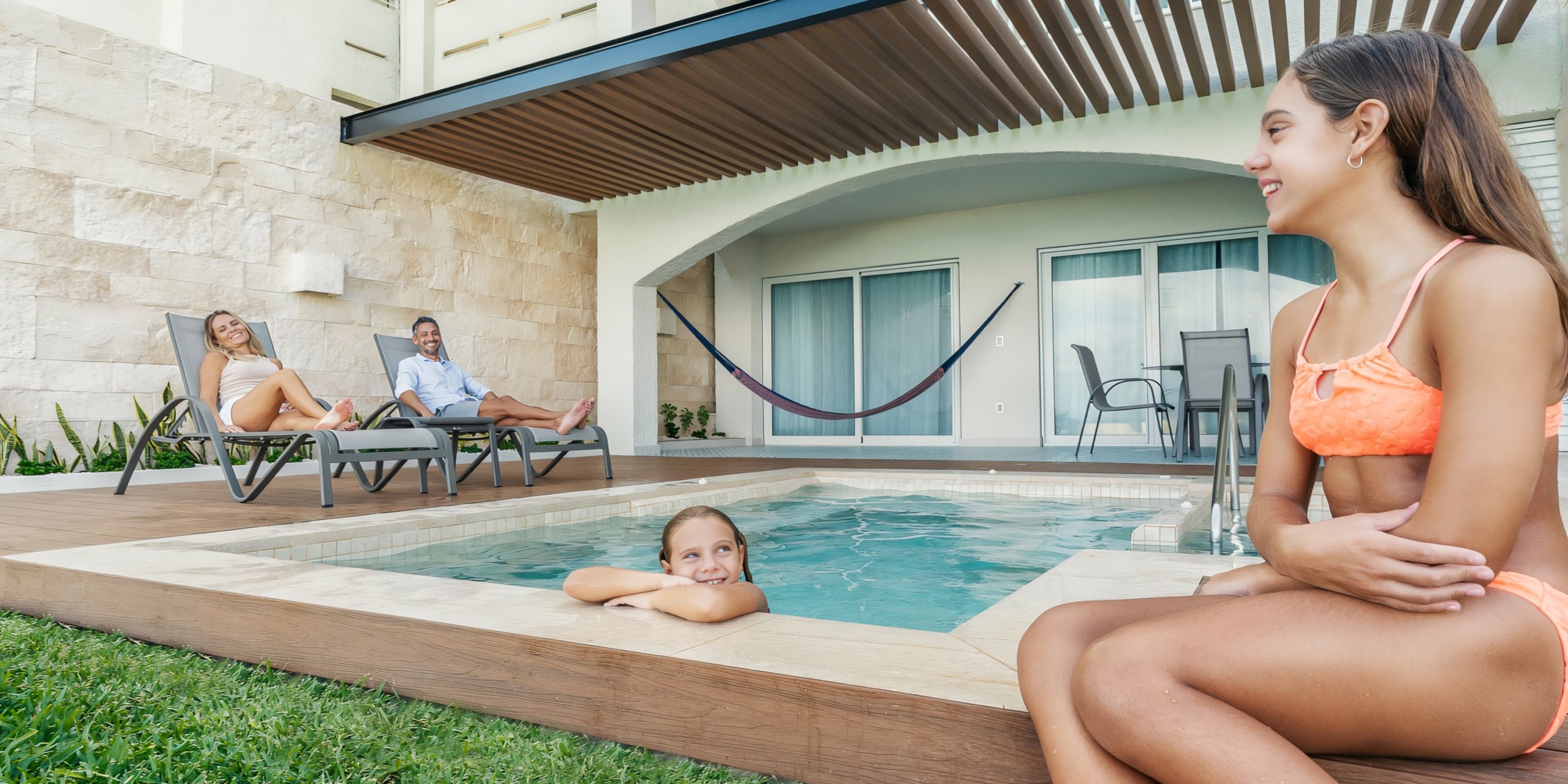 A family relaxing by a pool in their backyard; a young girl in the water, a woman lounging, and a man sitting at Hilton Cancun Mar Caribe.