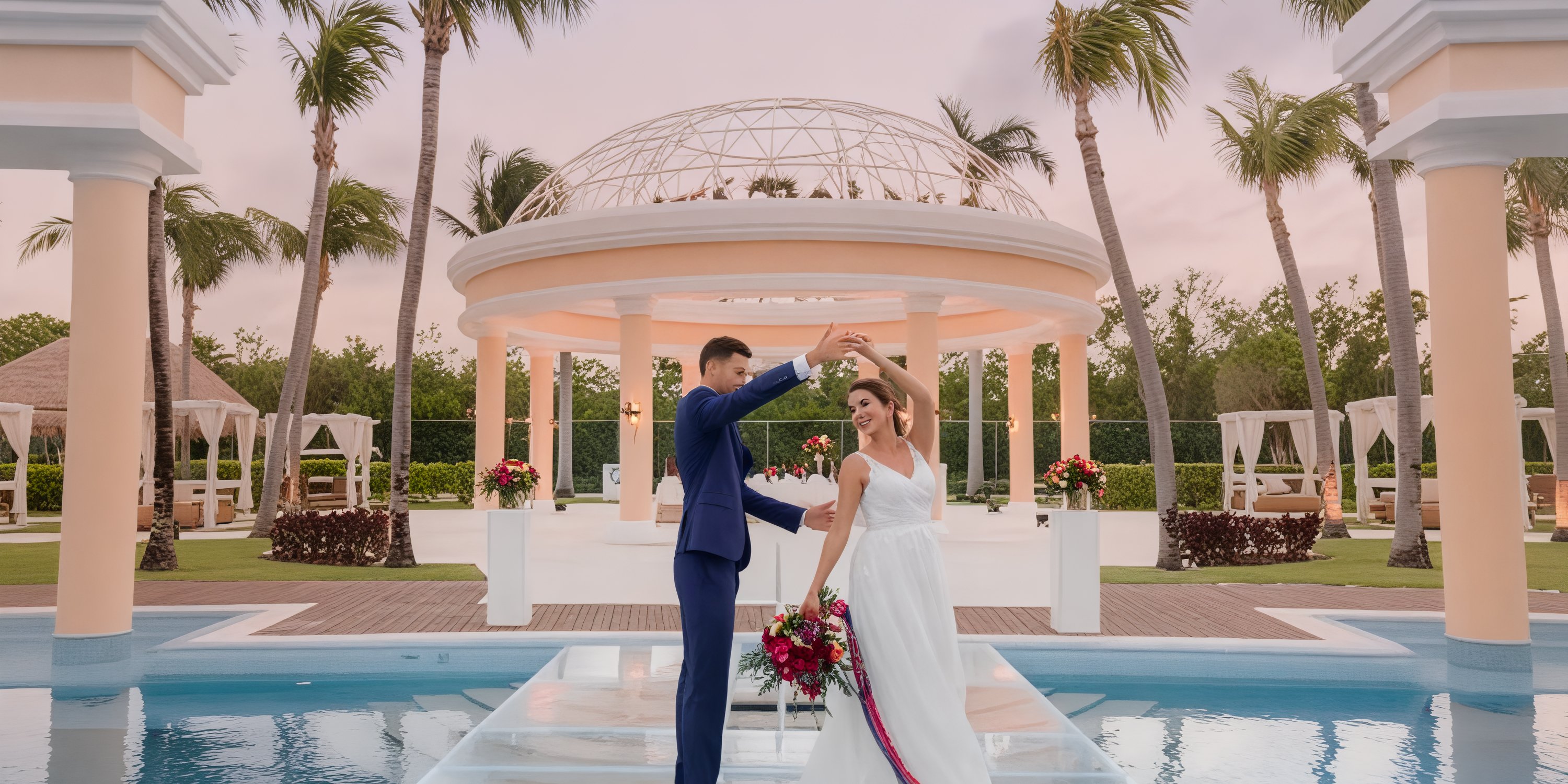 A couple celebrates their destination wedding by dancing on a glass platform at JOIA Paraiso by Iberostar, surrounded by swaying palm trees.