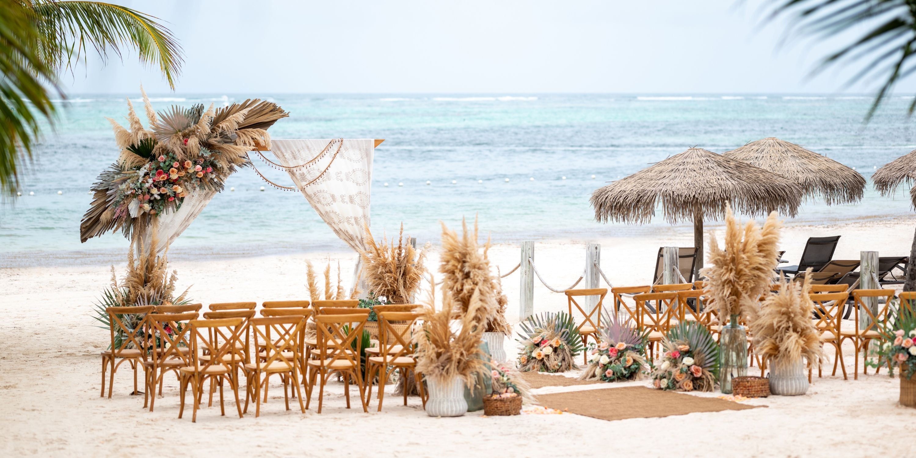Wooden chairs and floral decorations arranged for a destination wedding at Lopesan Costa Bavaro.