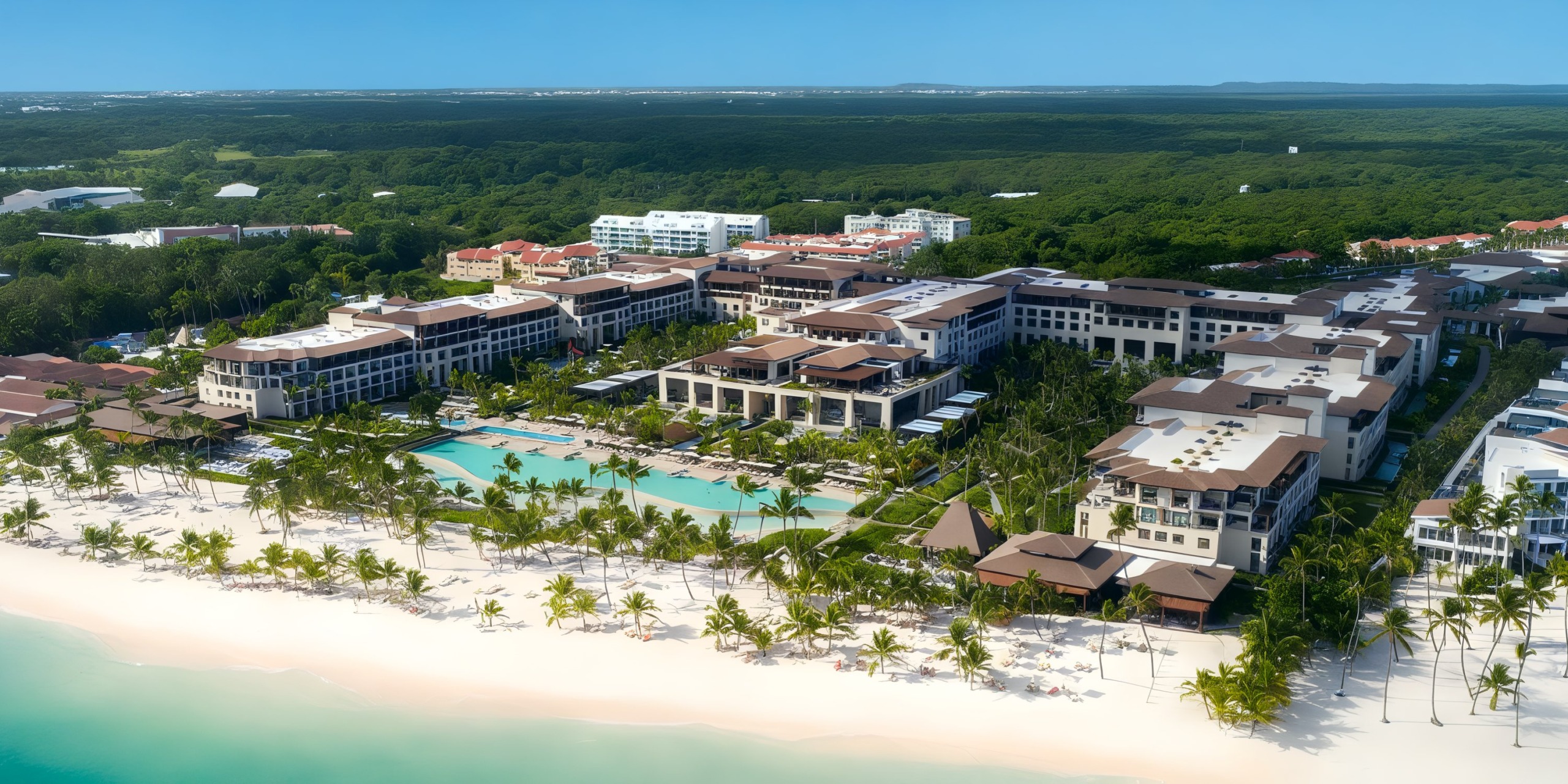 Aerial view of the Lopesan Costa Bavaro resort, featuring multiple buildings, pools, and palm trees, nestled next to a lush green forest and the ocean.