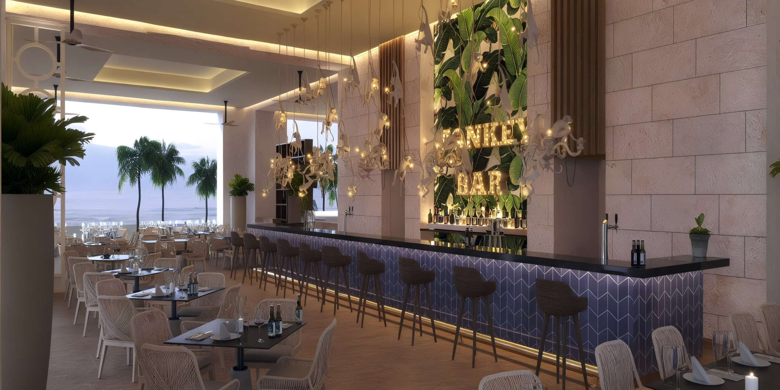 The Princess Grand Jamaica features a contemporary beachside bar with a long counter, stools, and tables. A lively green leaf wall is adorned with the name "Monkey Bar," while palm trees and the ocean can be seen through large open windows.