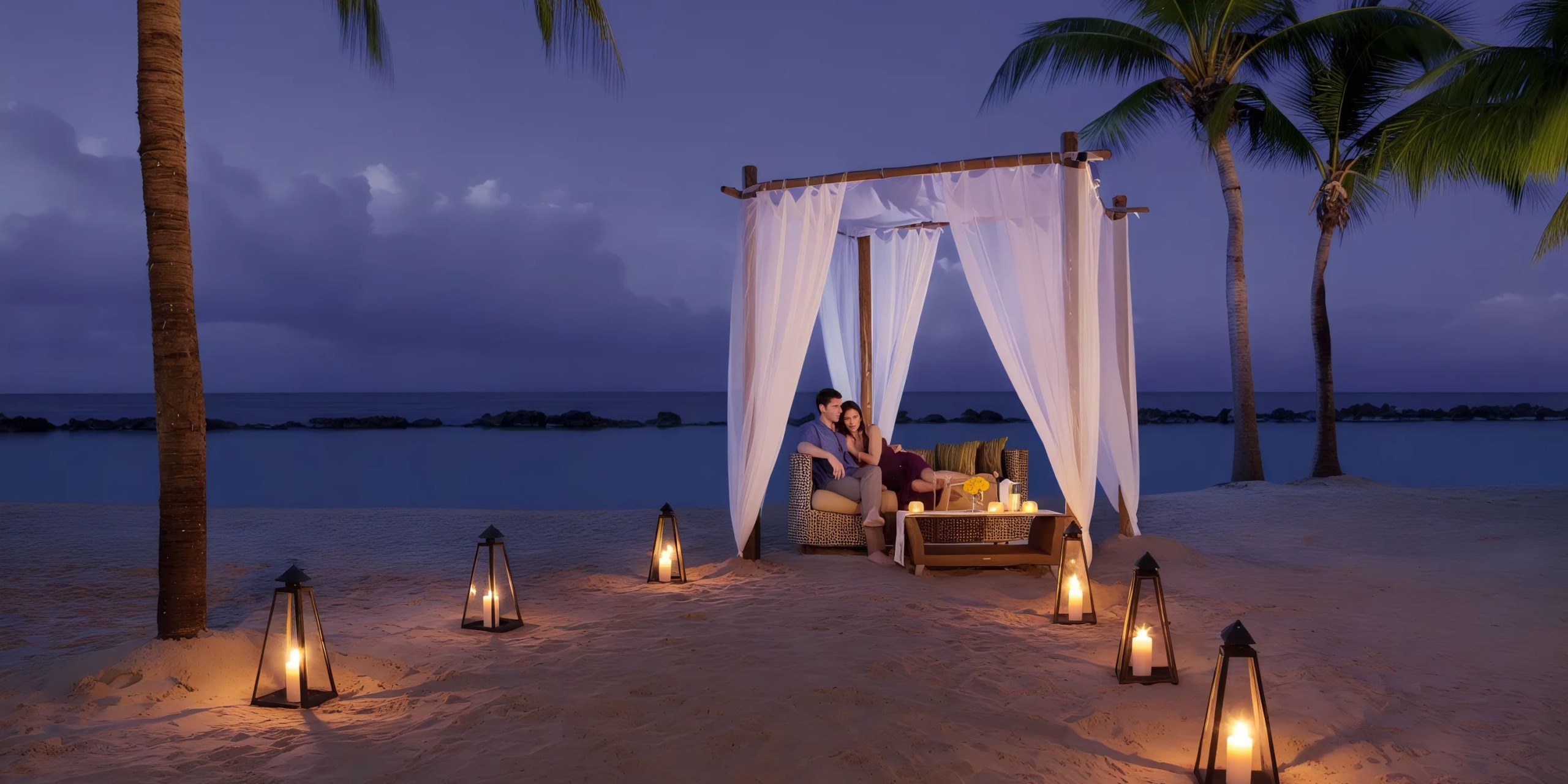 A couple sits under a canopy at Sunscape Dominicus La Romana on a beach at dusk, surrounded by lanterns, with palm trees and the ocean in the background.