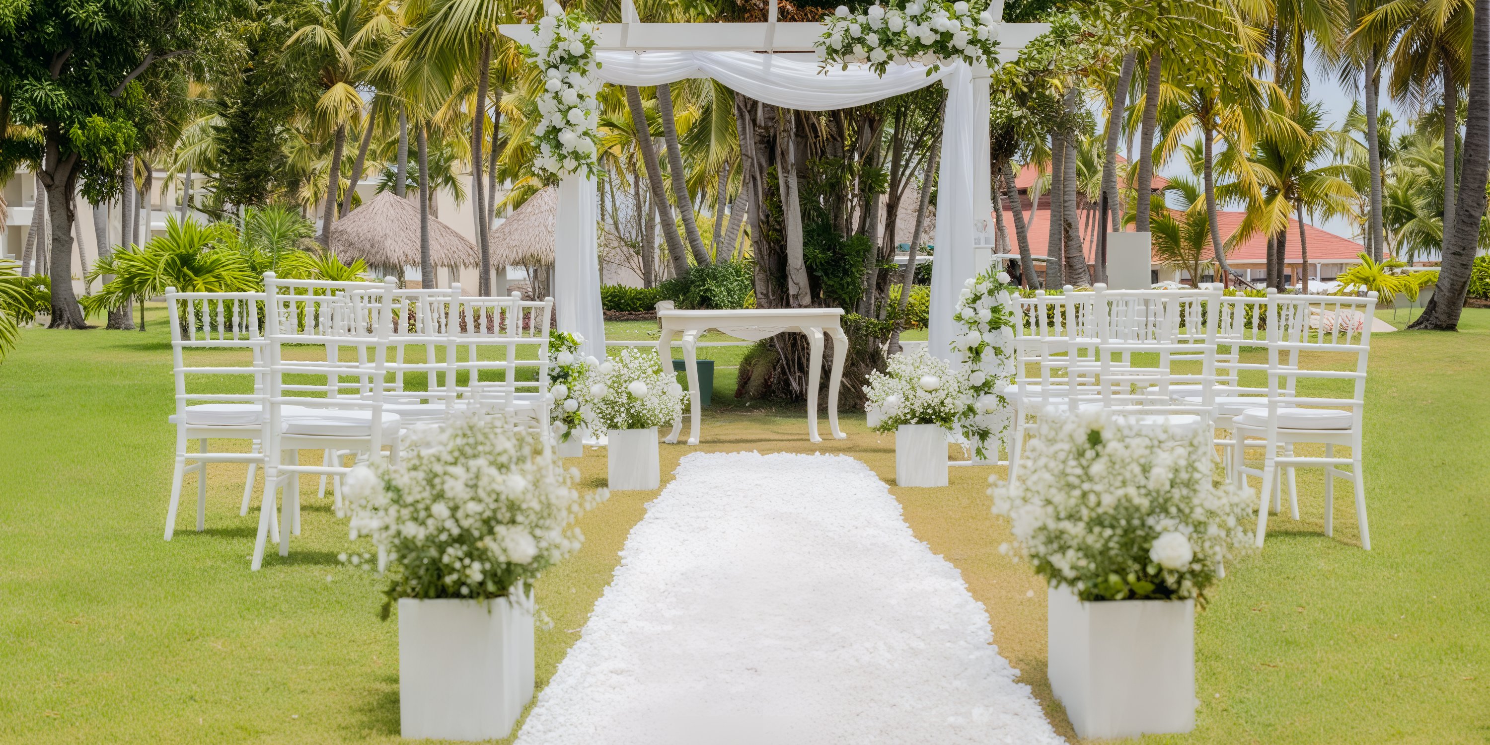 Experience a breathtaking destination wedding at Princess Grand Jamaica, complete with an outdoor setting featuring a beautifully adorned aisle, elegant chairs, vibrant flowers, and majestic palm trees.