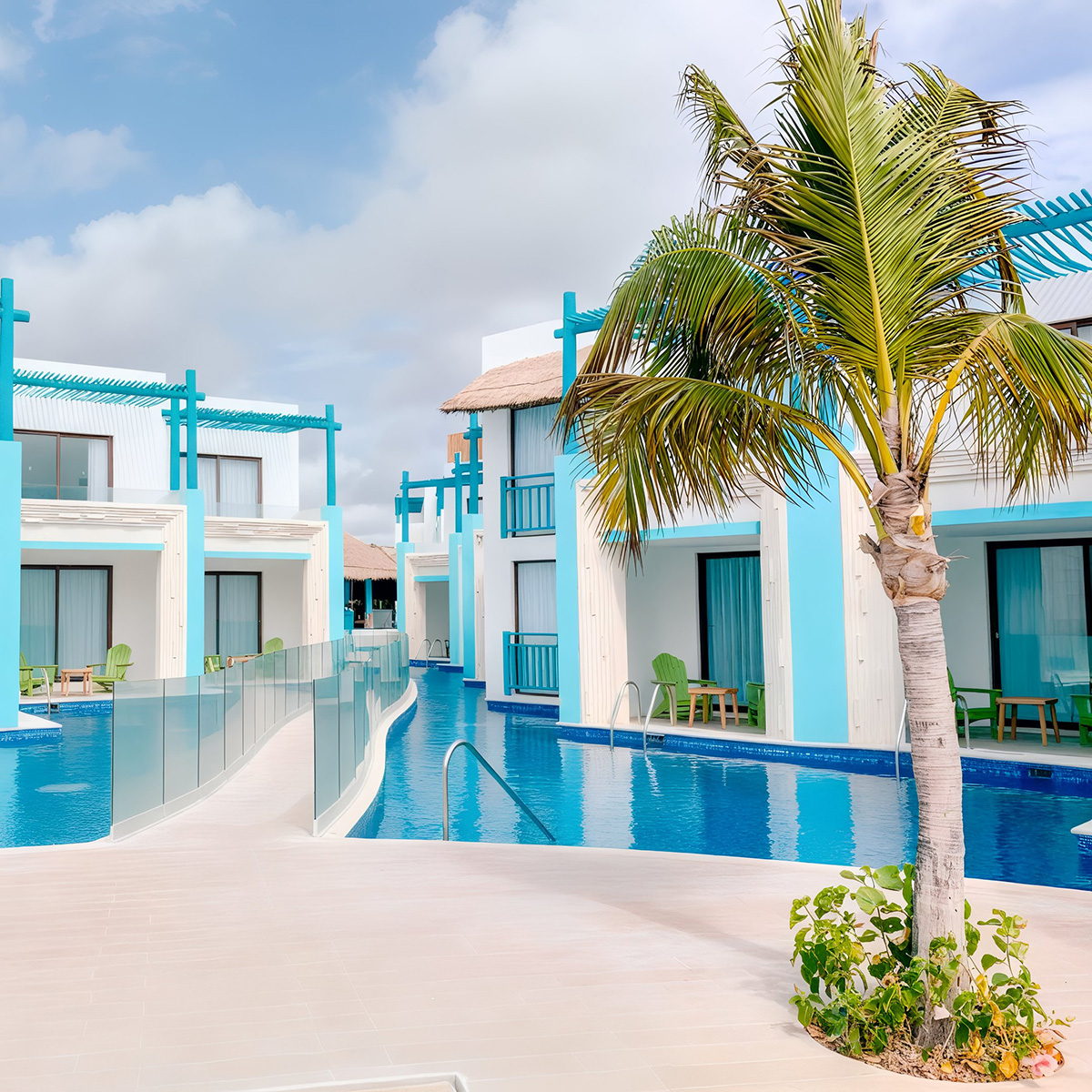 The Margaritaville Island Reserve Resort Riviera Cancun features modern blue and white buildings, a swimming pool, and palm trees under a partly cloudy sky.