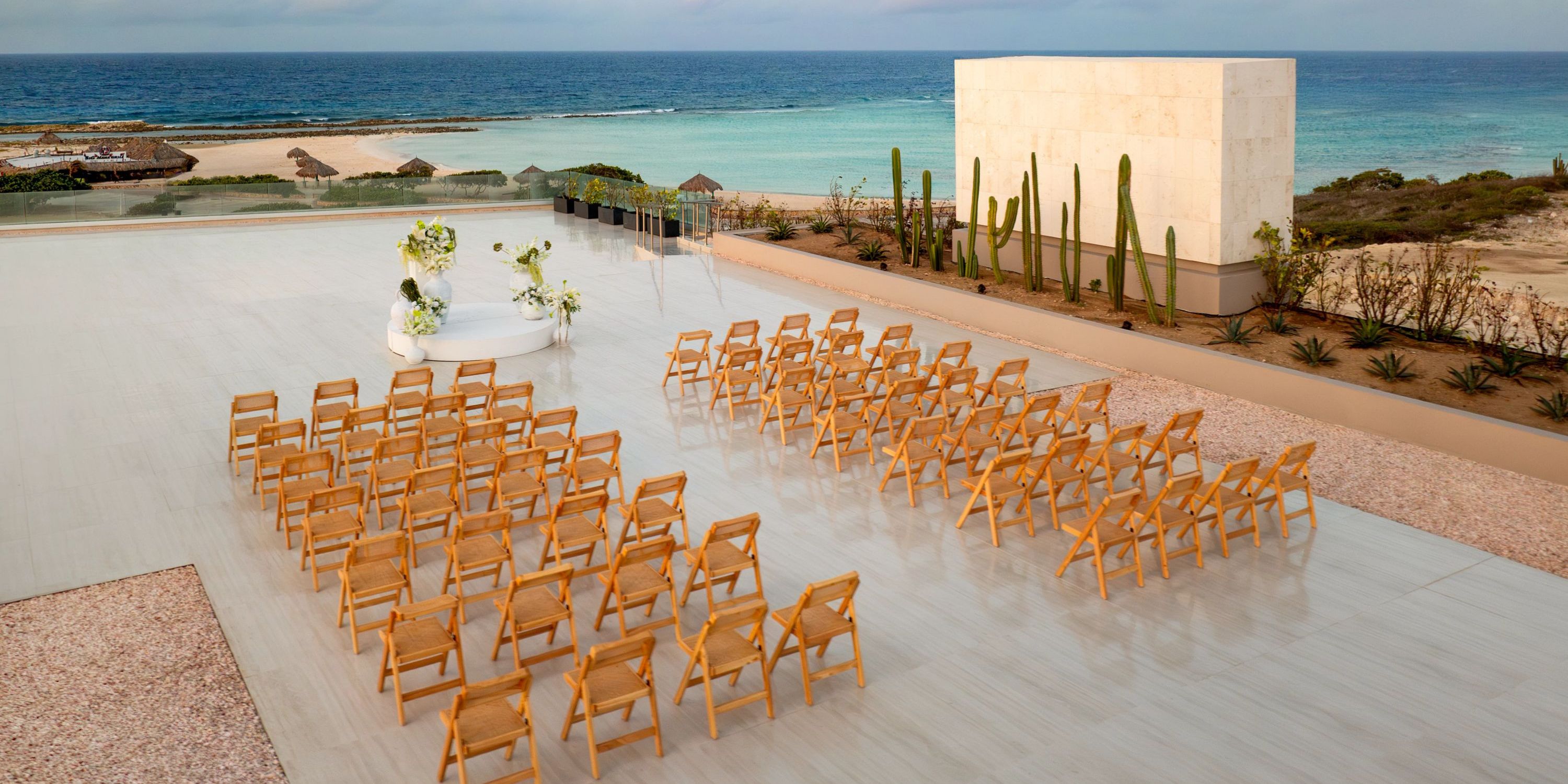 Wooden chairs arranged for a destination wedding ceremony at Secrets Baby Beach Aruba.