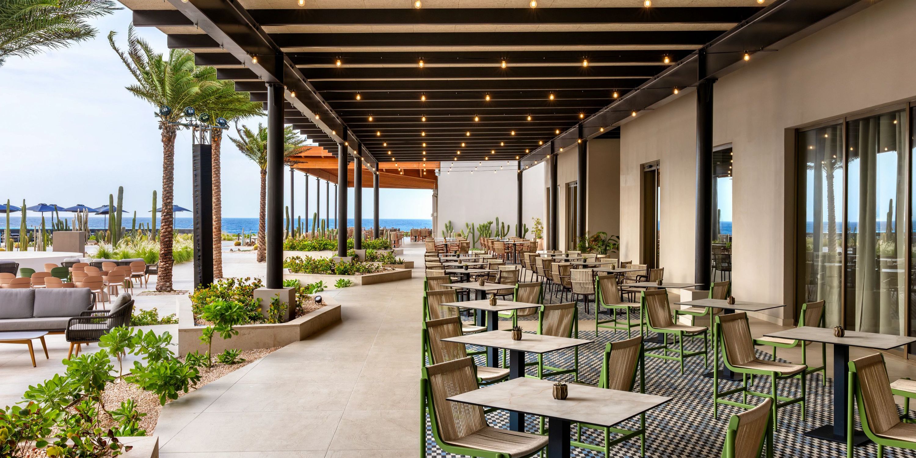 Secrets Baby Beach Aruba outdoor patio with tables and chairs, perfect for a destination wedding by the ocean.