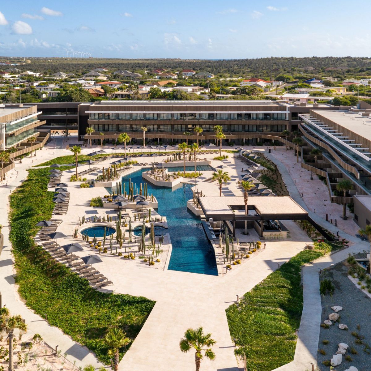 Aerial view of Secrets Baby Beach Aruba, perfect for a destination wedding, with pool and palm trees.