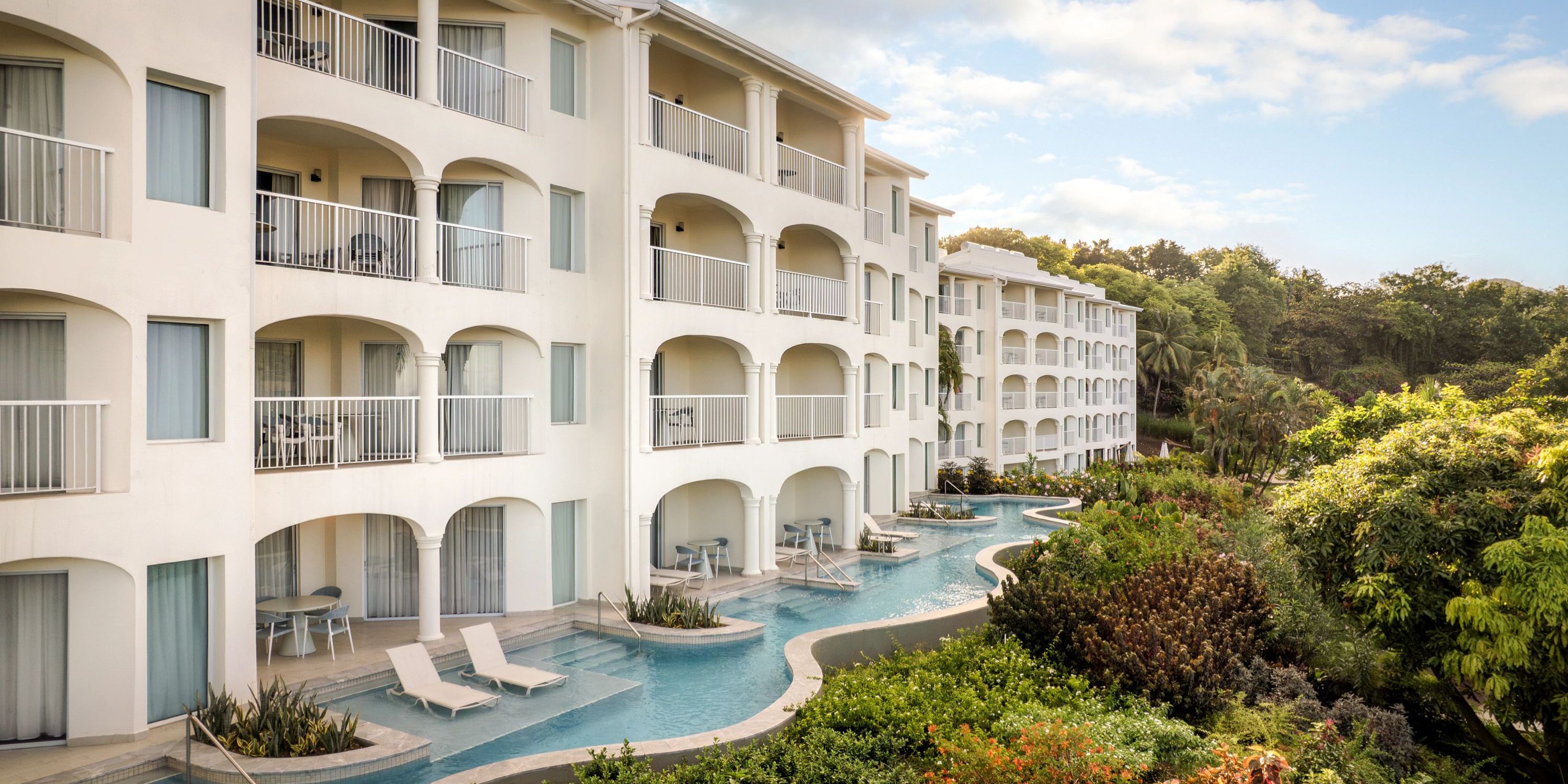 Secrets St Lucia: Elegant white resort with balconies, winding pool, gardens—ideal for a destination wedding.
