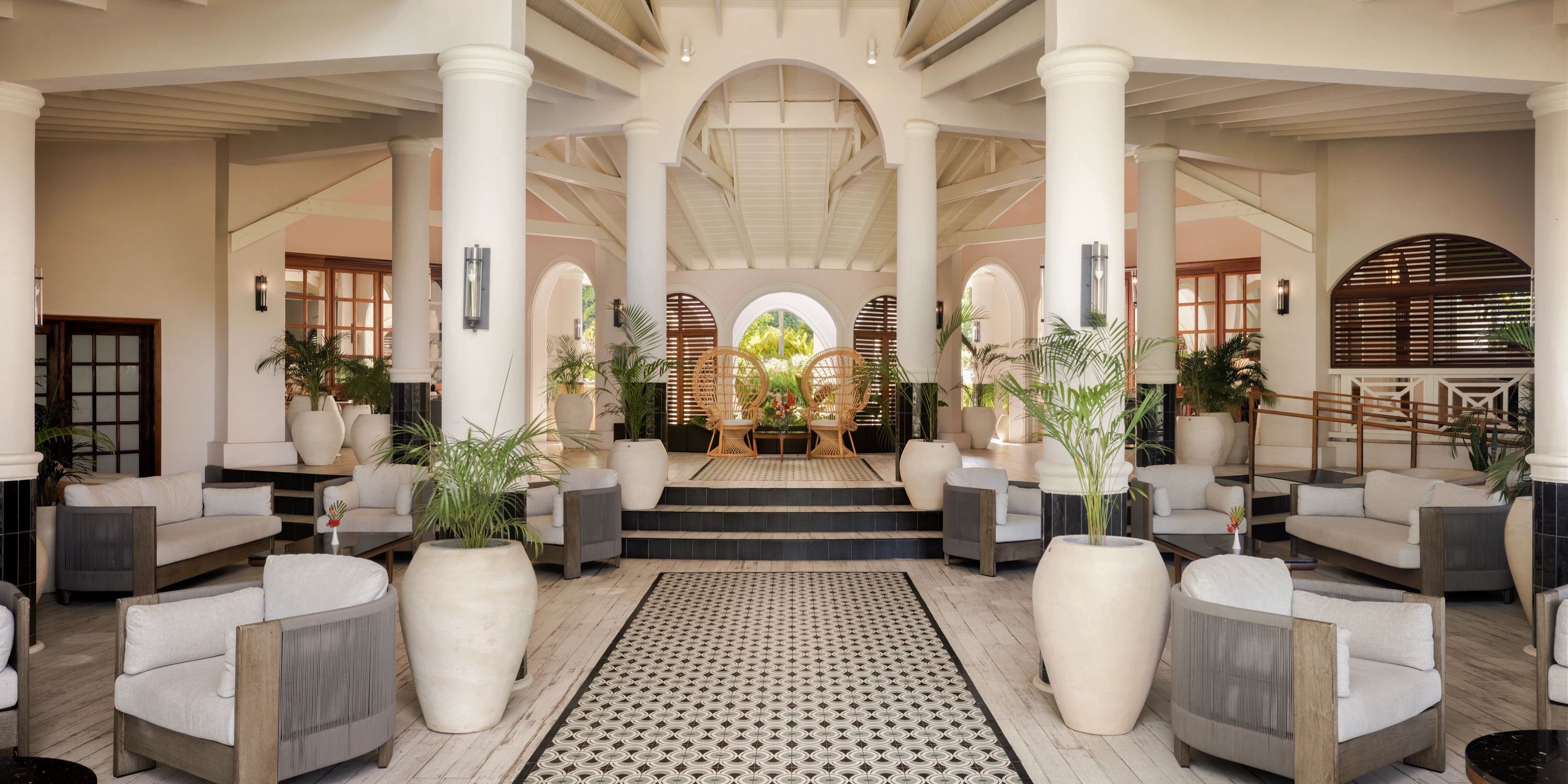 Secrets St Lucia lobby, ideal for a destination wedding, with armchairs, lush plants, and outdoor archways.