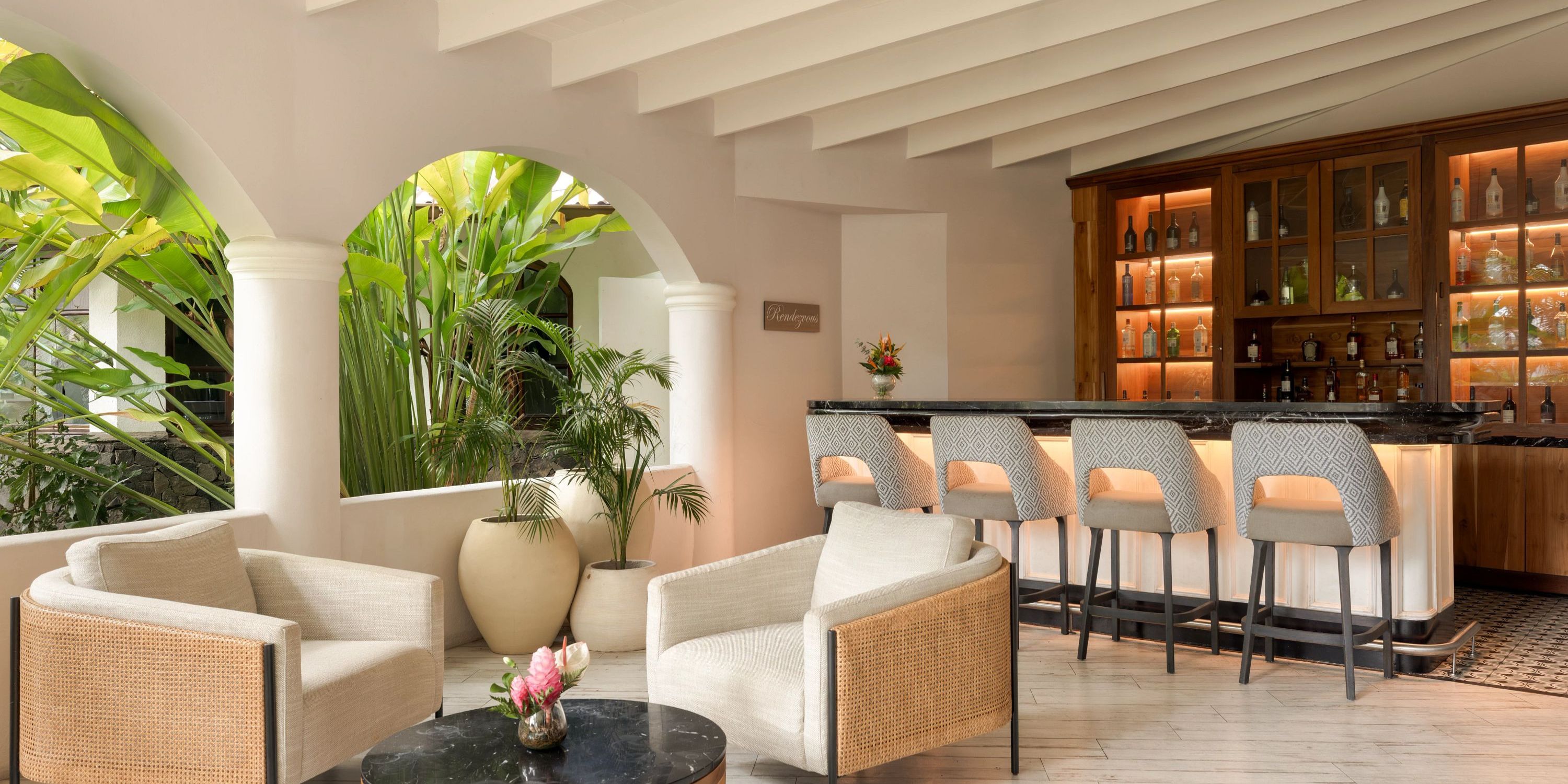 Secrets St Lucia offers a chic indoor bar, ideal for a destination wedding, with lounge chairs and lush plants.