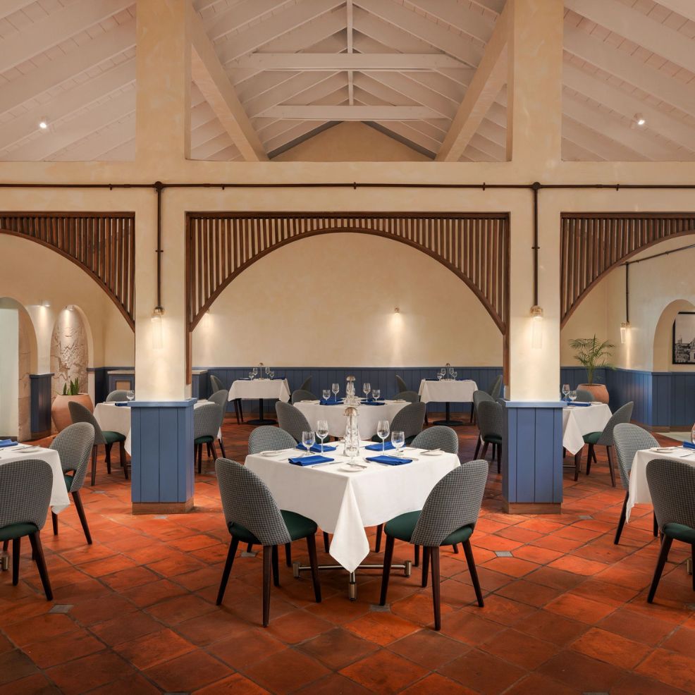 Elegant restaurant with white tablecloths, blue accents, and terracotta tiles, perfect for a wedding.