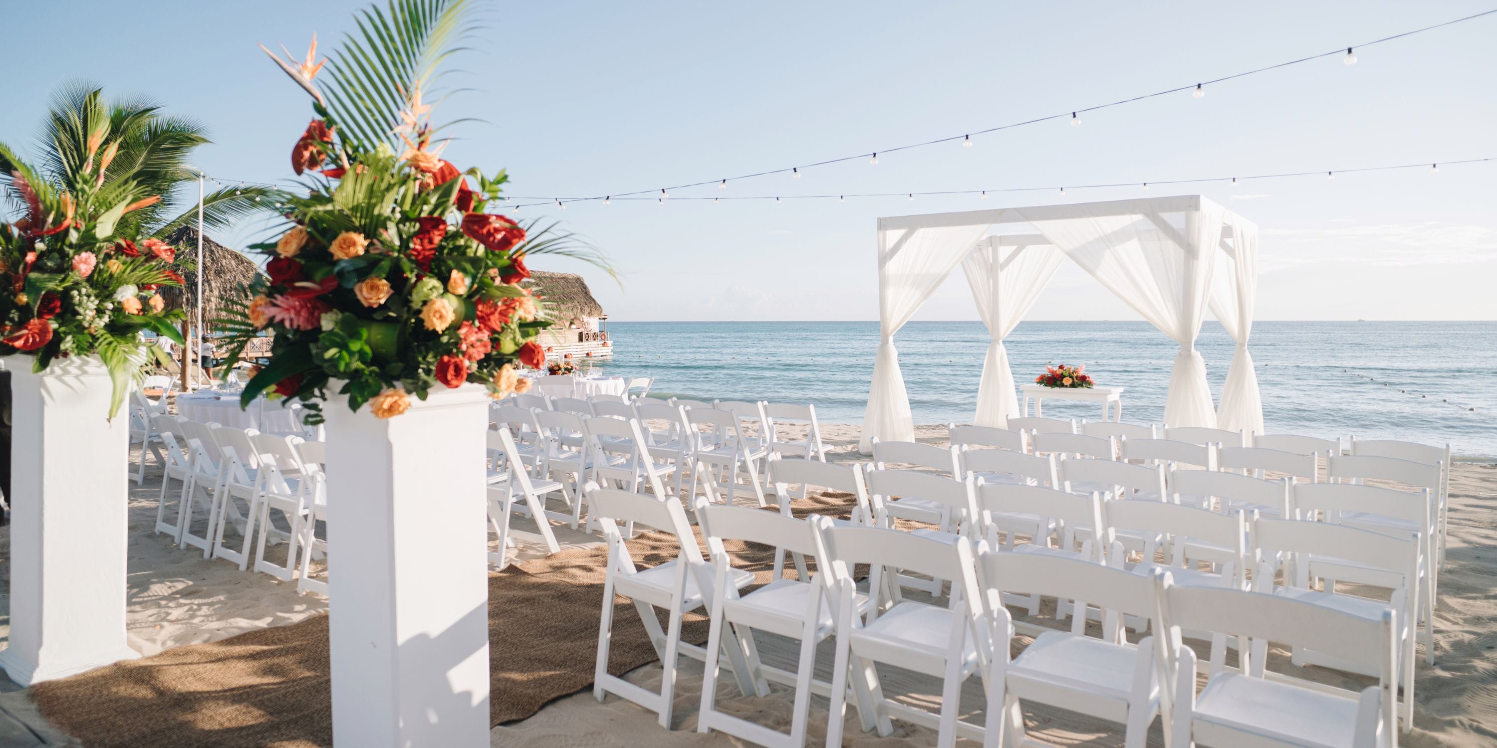 Chic white chairs and florals arranged for a destination wedding on the beach at Sunscape Dominicus La Romana.