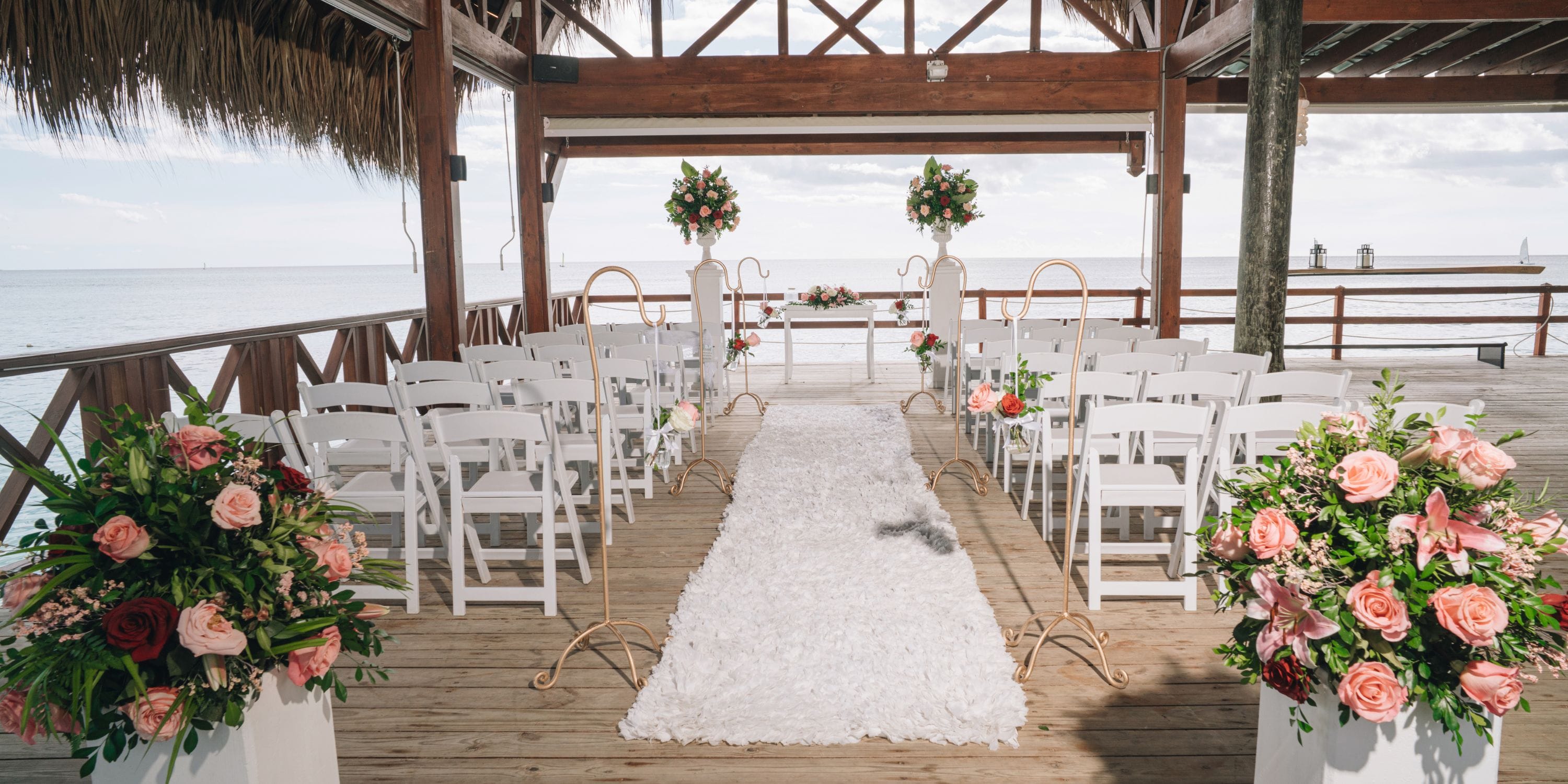 Destination wedding setup at Sunscape Dominicus La Romana featuring white chairs, flowers, and waterfront aisle.