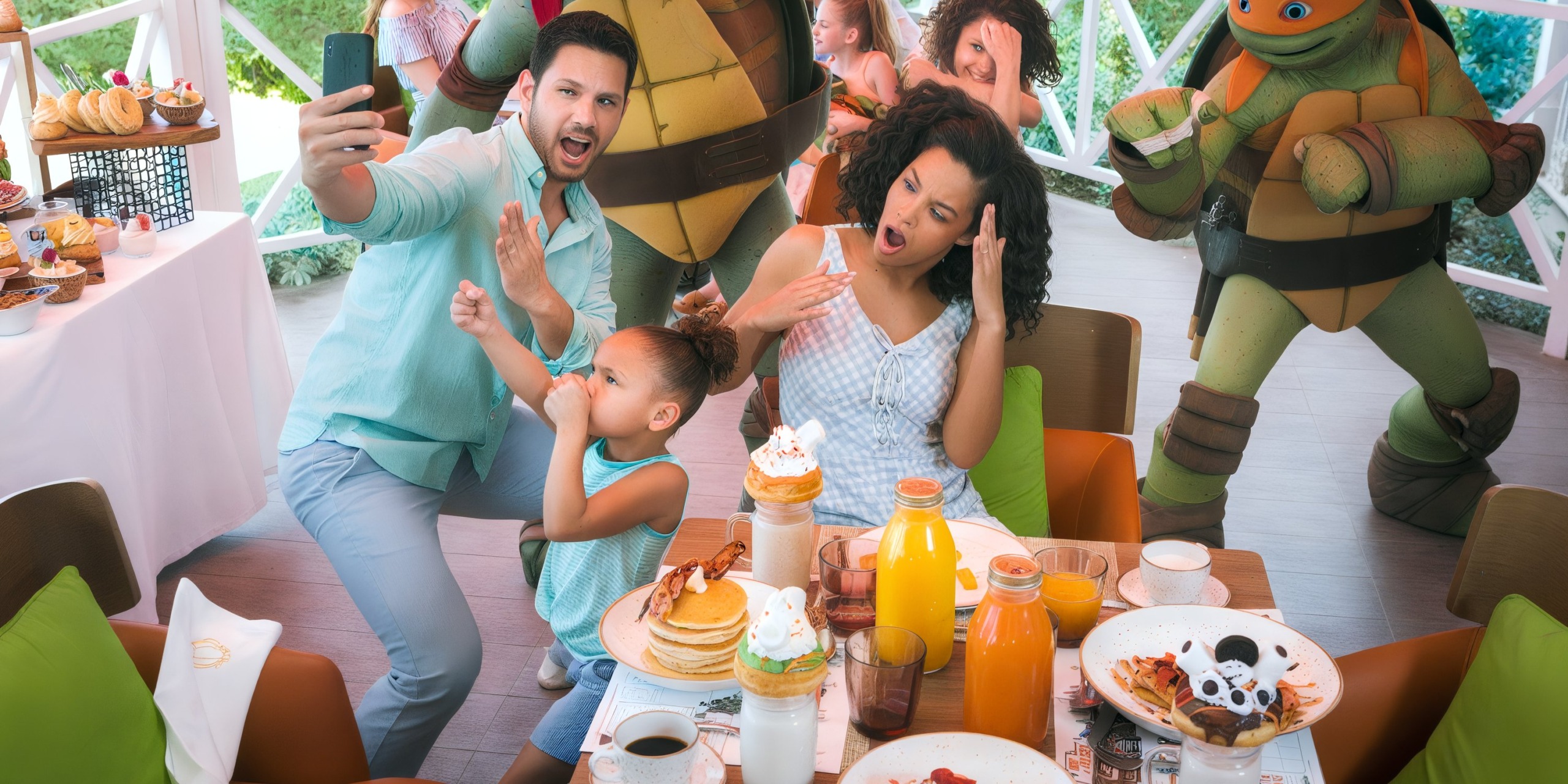 A family poses for a selfie at a restaurant table with pancakes and drinks, surrounded by people in turtle costumes at Nickelodeon Hotels & Resorts Riviera Maya.