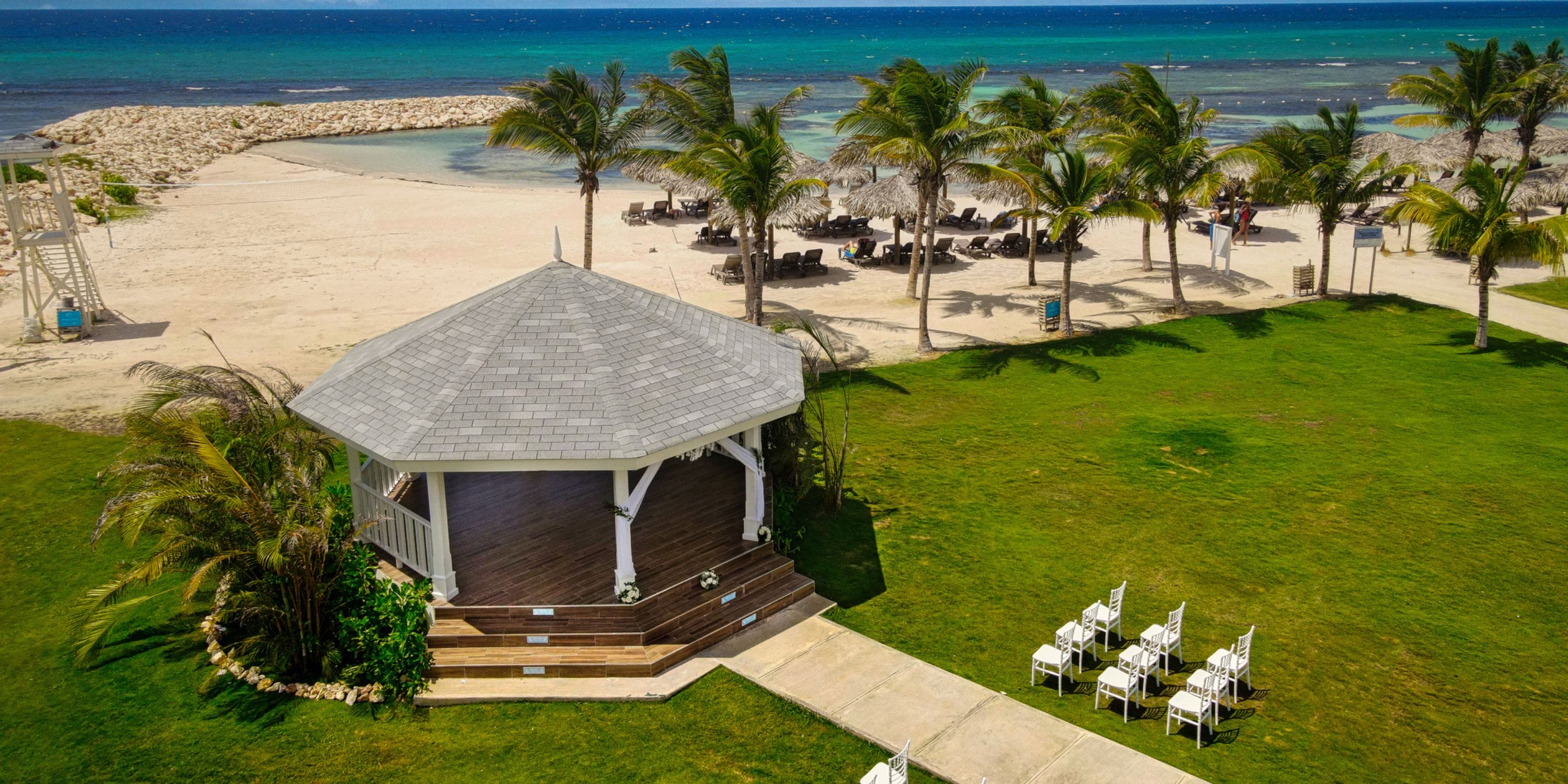 Ocean Eden Bay: beachfront gazebo with chairs, palm trees, and ocean views—perfect for a destination wedding.