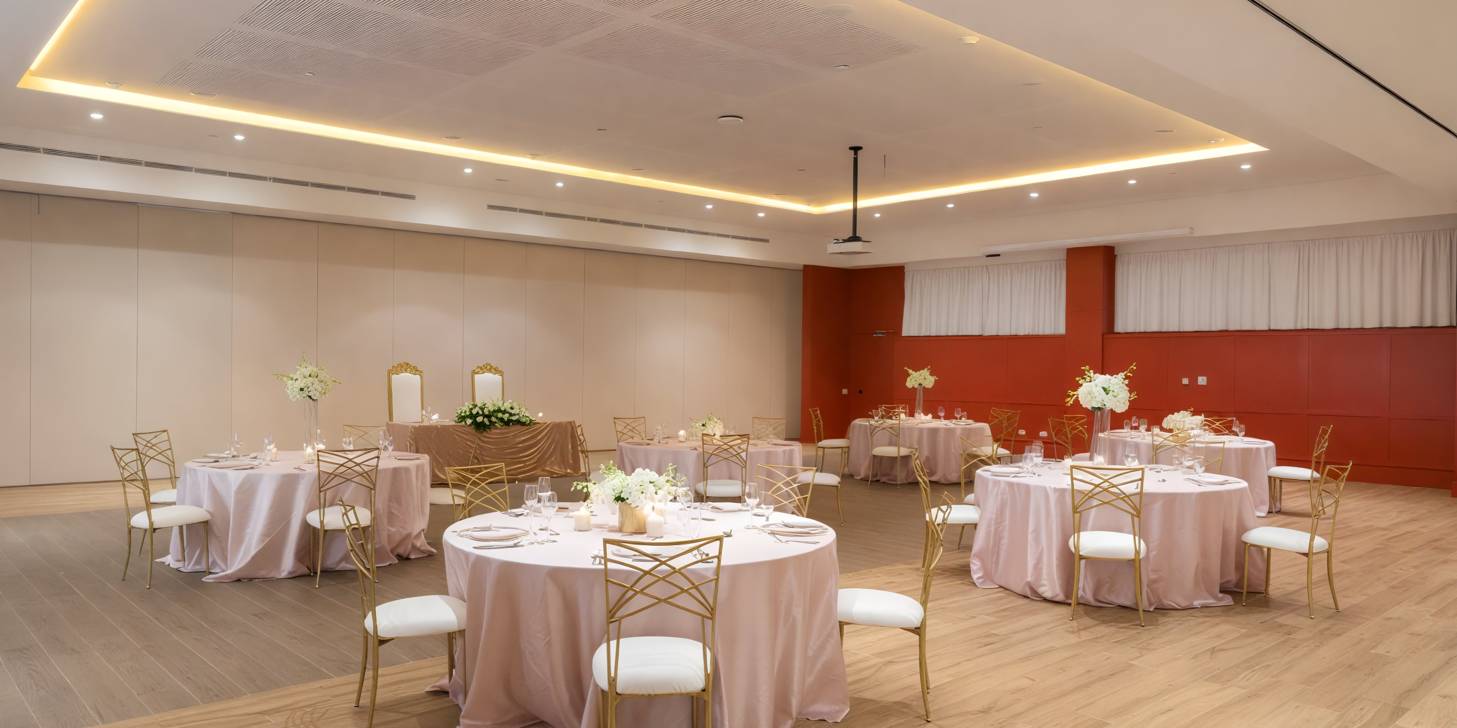 The hall at Ocean Eden Bay was elegantly transformed for the wedding, featuring floral centerpieces, gold chairs, and round tables—an ideal setting for a dream destination wedding.