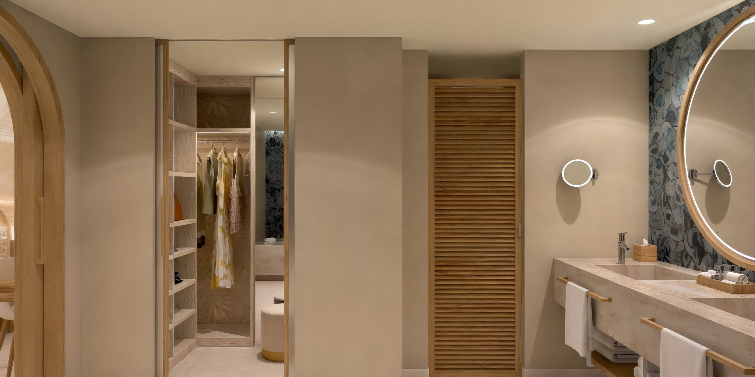 Experience a contemporary bathroom at Dreams Playa Esmeralda, featuring a sophisticated sink, elegant mirror, open wardrobe, and a softly lighted closet—perfect for preparing for your dream destination wedding.