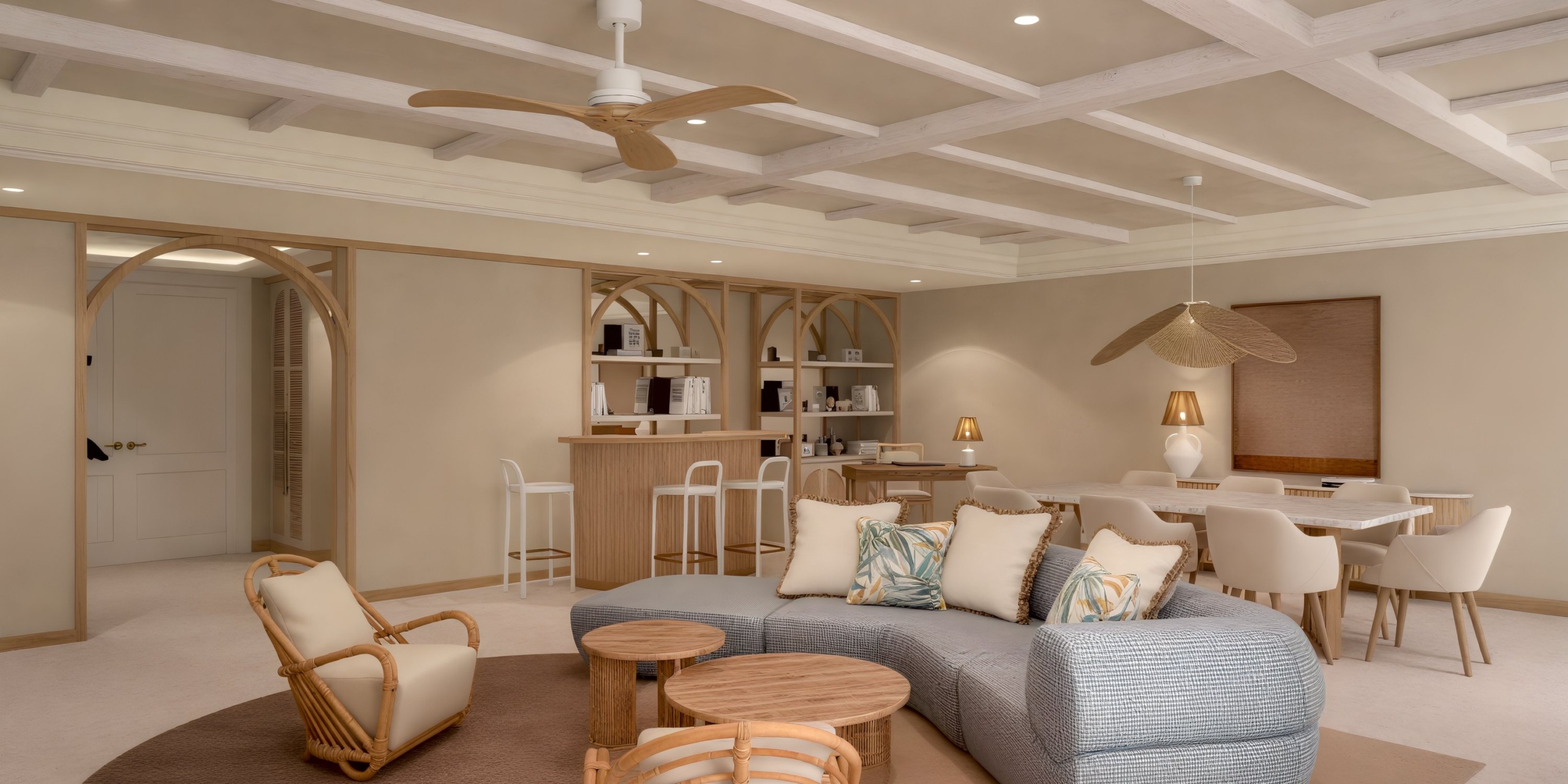 Dreams Playa Esmeralda living area is an ideal setting for a destination wedding, featuring a chic beige sofa, a stylish bar, a sophisticated dining set, and elegant wooden accents—all elegantly complemented by a ceiling fan.