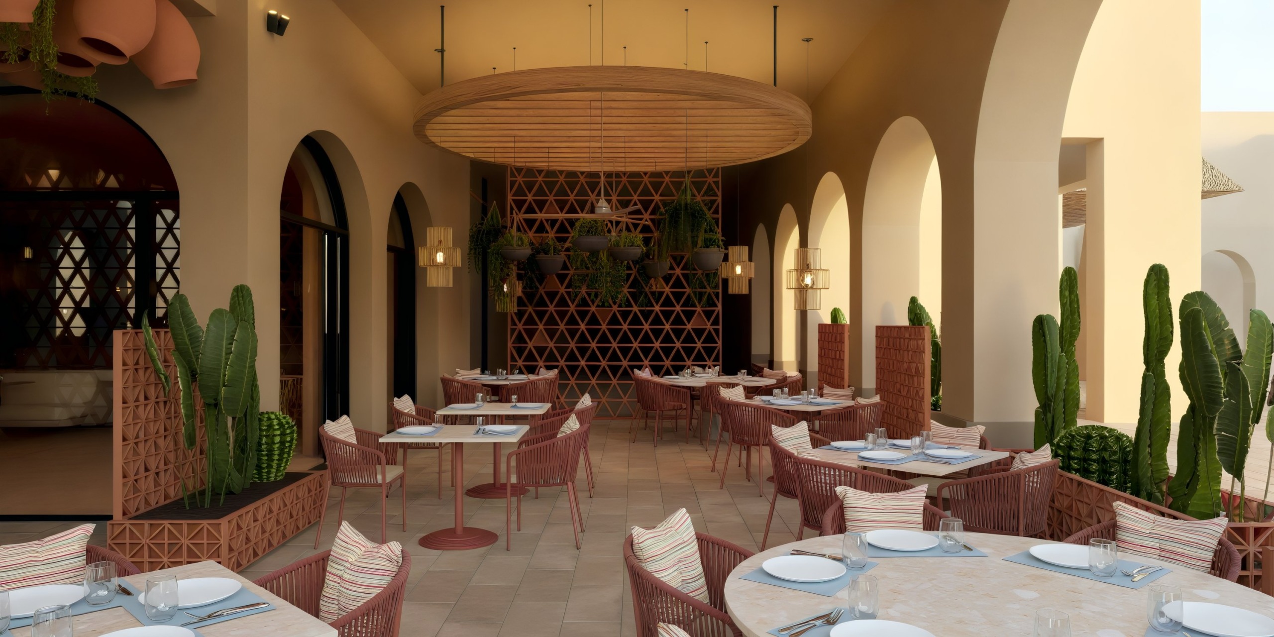 Patio at Dreams Playa Esmeralda, perfect for a destination wedding, featuring tables, chairs, cacti, and an intricately designed wall.