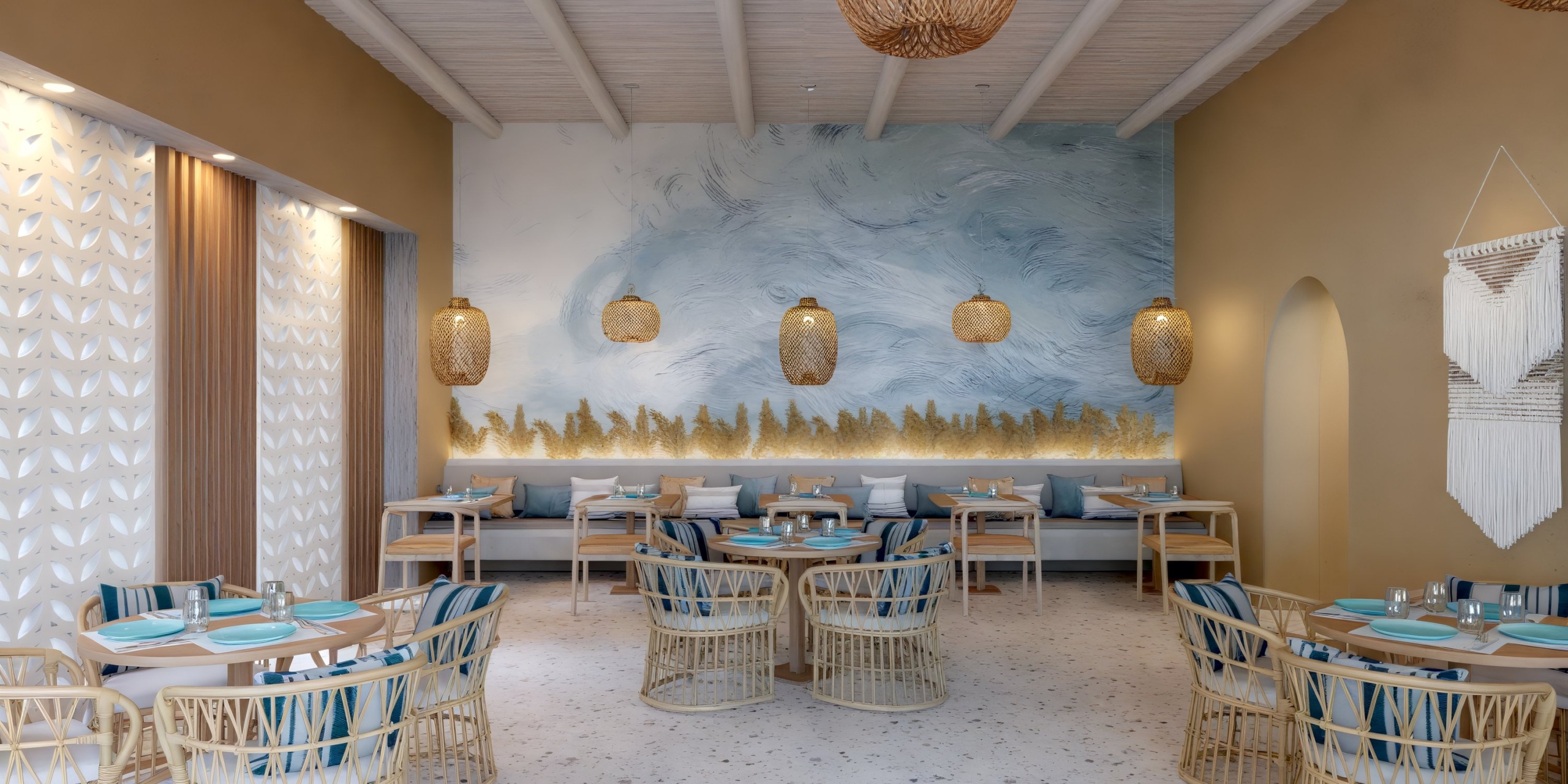 Dreams Playa Esmeralda's interior, perfect for a destination wedding, features woven chairs, stunning wall art, and elegant hanging lights.