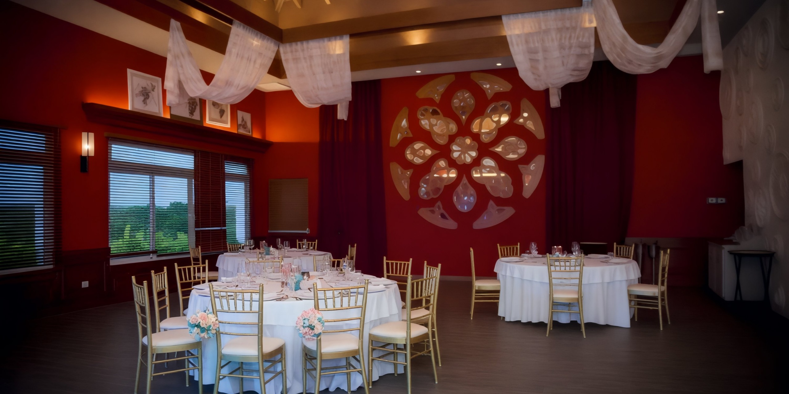 An elegant banquet hall featuring round tables adorned with white tablecloths and complemented by gold chairs, perfect for a wedding or destination wedding.