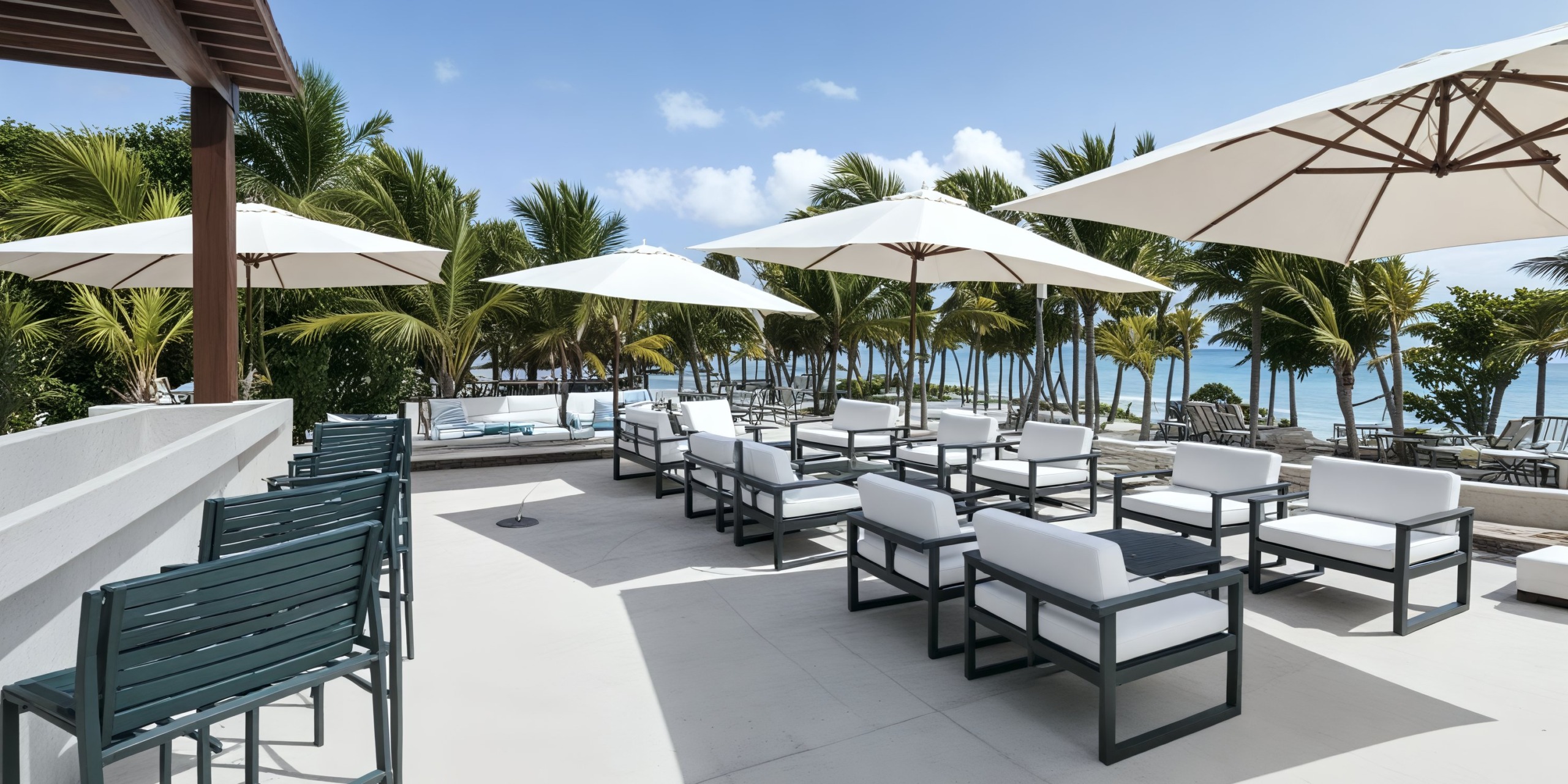 A picturesque outdoor seating area with umbrellas and palm trees near the ocean, perfect for a destination wedding.