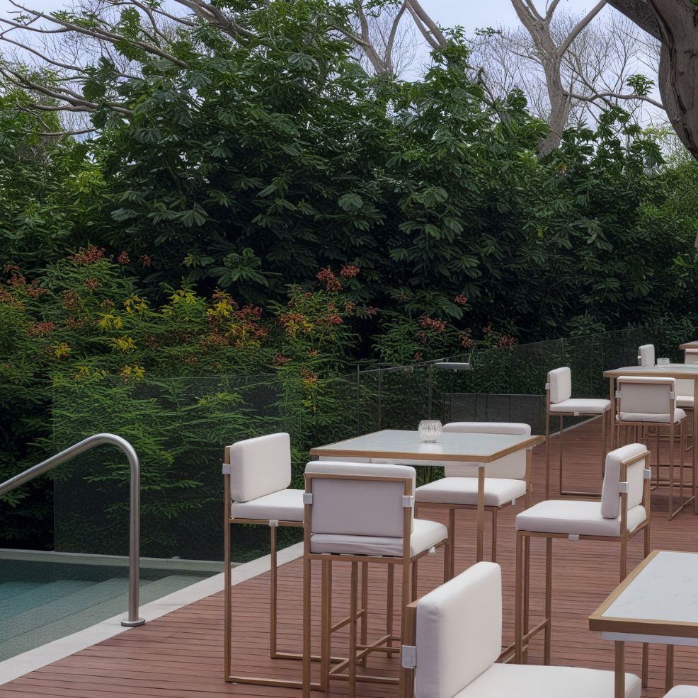 An enchanting outdoor seating area, perfect for a destination wedding, features elegant white chairs and tables arranged on a wooden deck, beautifully surrounded by lush green foliage.