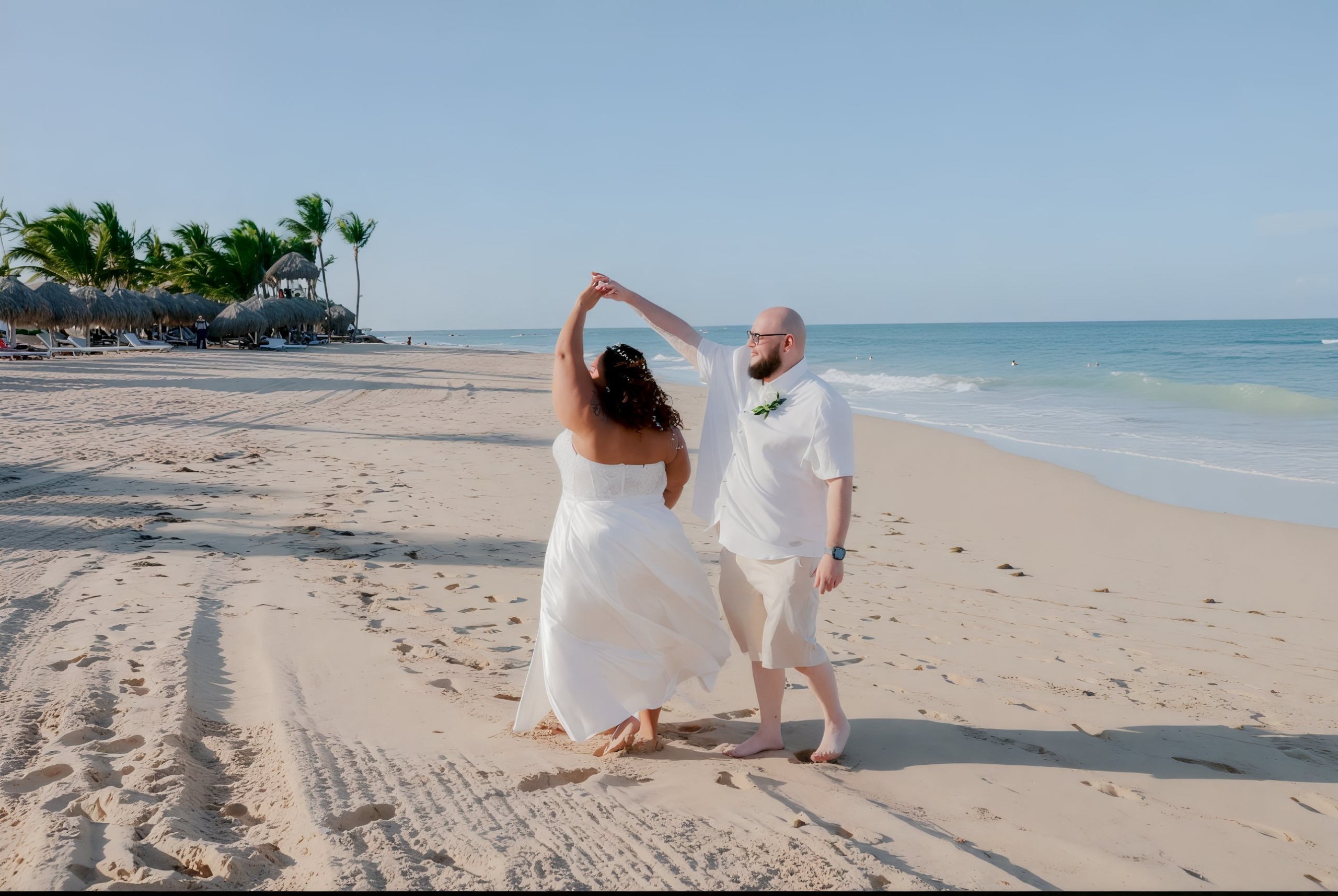 A couple dancing on a sandy beach with the ocean in the background, creating a picturesque scene at their destination wedding.