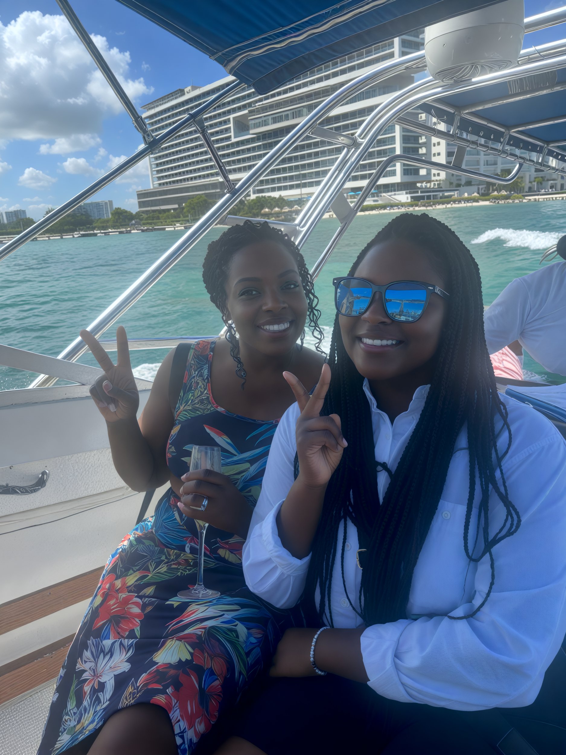 Sheneka and Andre are on a boat, joyfully displaying peace signs with their fingers as they celebrate their destination wedding.