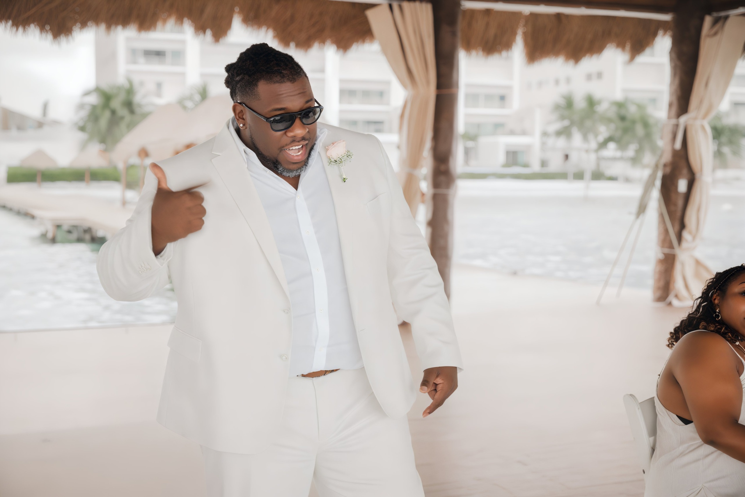 Sheneka and Andre are giving a thumbs-up at their beautiful poolside resort, excited for their upcoming destination wedding.