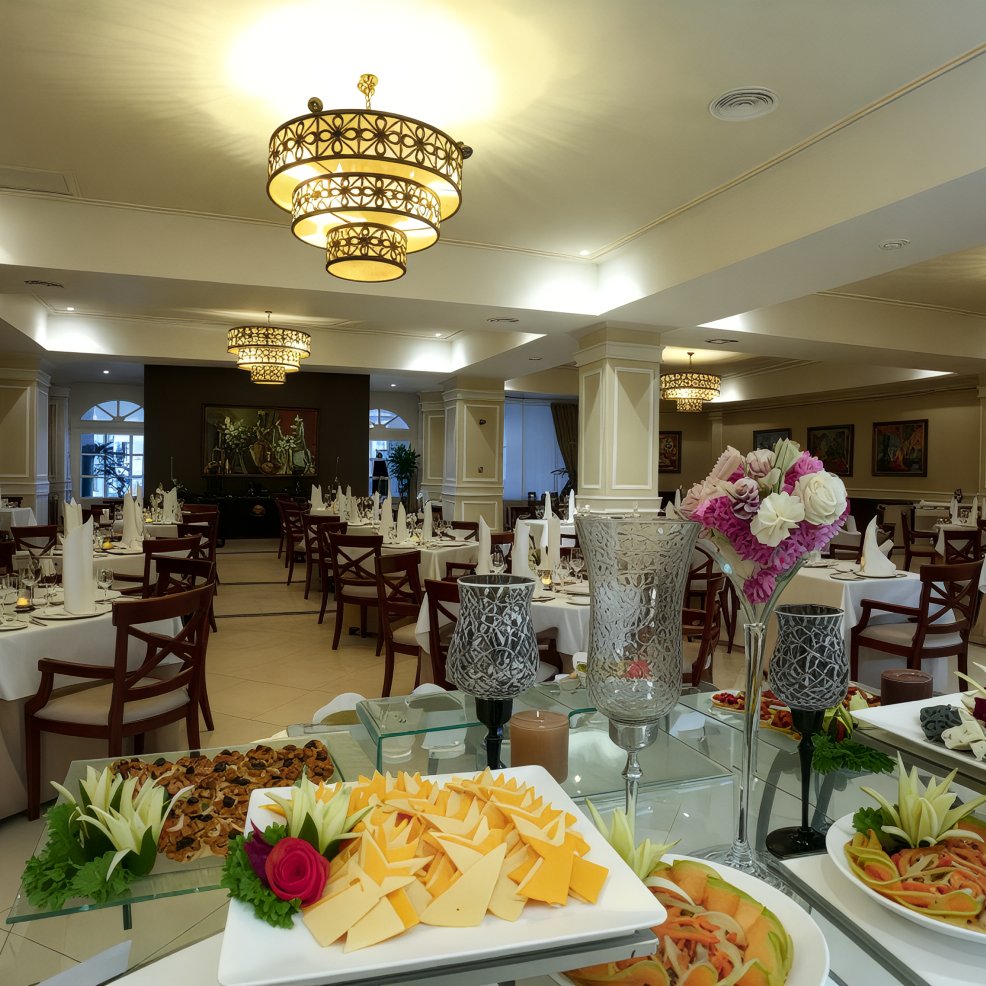 The elegant restaurant interior is beautifully arranged for a wedding, with tables set for dining and an assortment of appetizers on display.