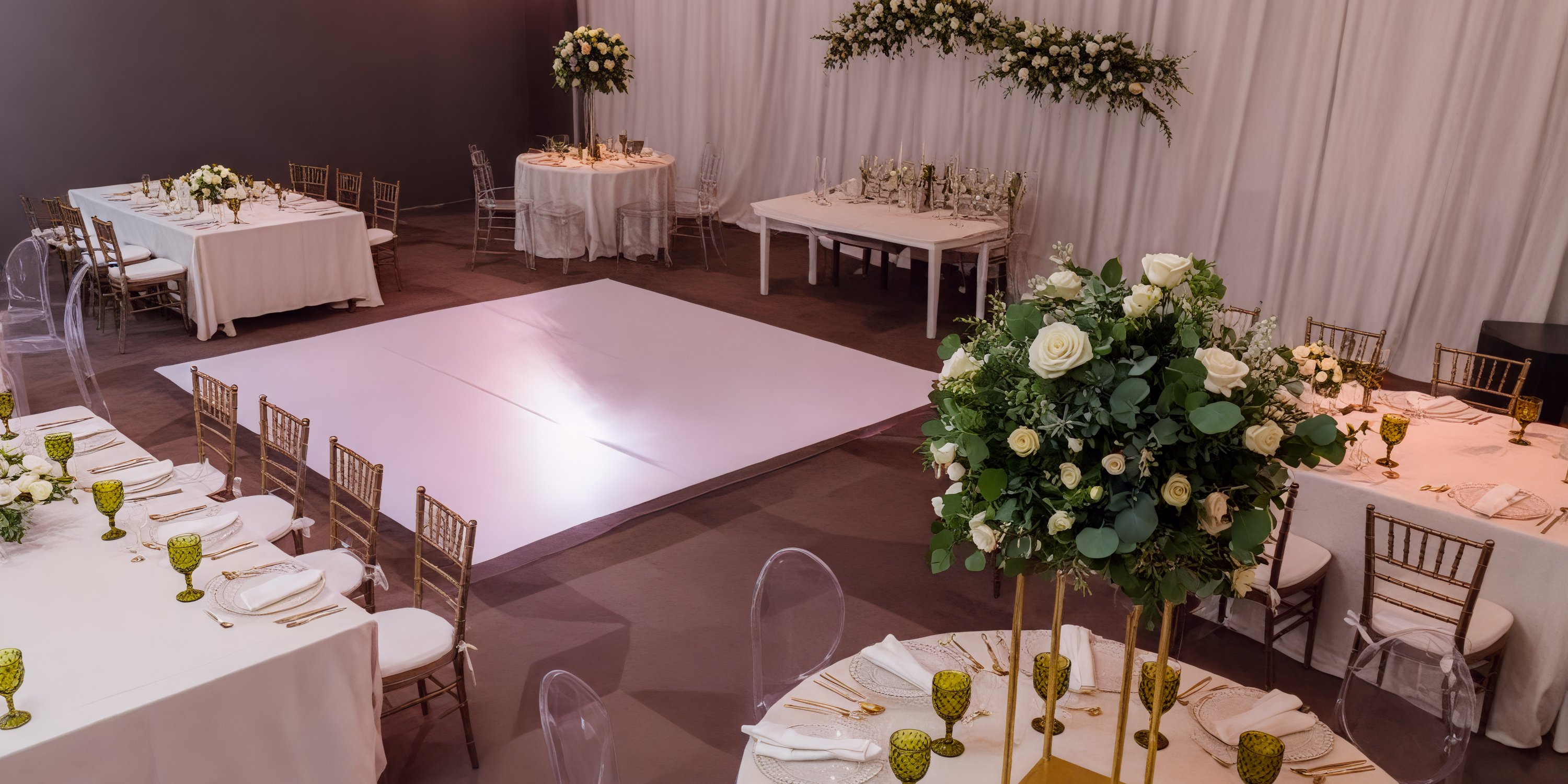 The wedding venue is elegantly adorned with tables, chairs, and floral arrangements surrounding a vibrant dance floor. Perfect for any destination wedding.