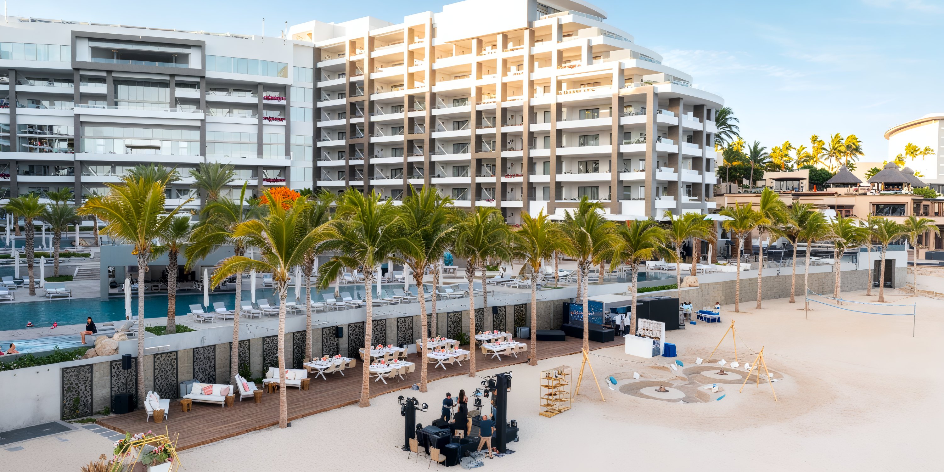 Garza Blanca Los Cabos: A stunning beachfront hotel featuring palm trees, outdoor seating, and a pristine sandy beach—an ideal venue for a destination wedding.