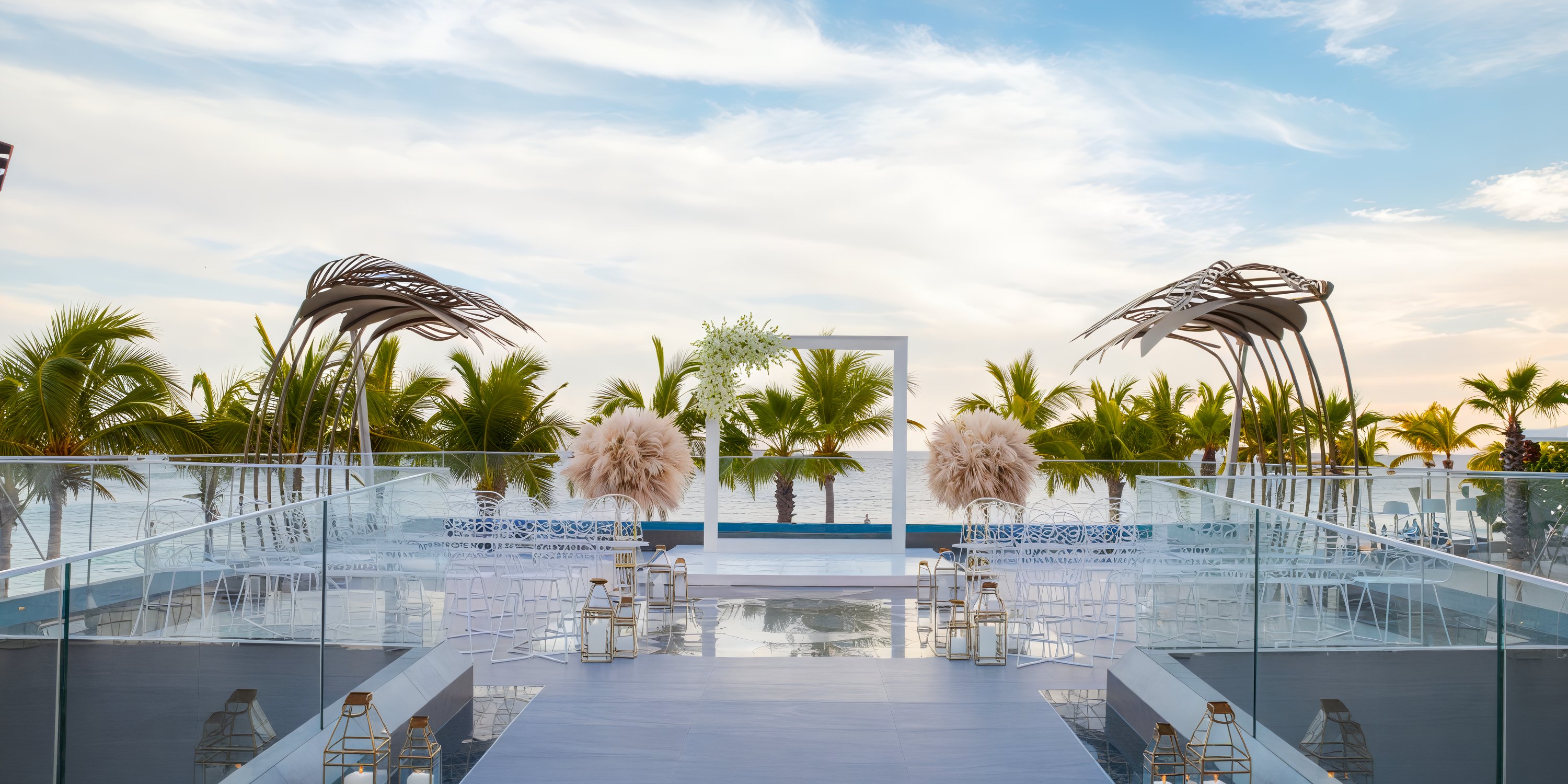 Garza Blanca Los Cabos offers a stunning destination wedding setting featuring an outdoor altar by the sea, surrounded by chairs and elegant palm trees.