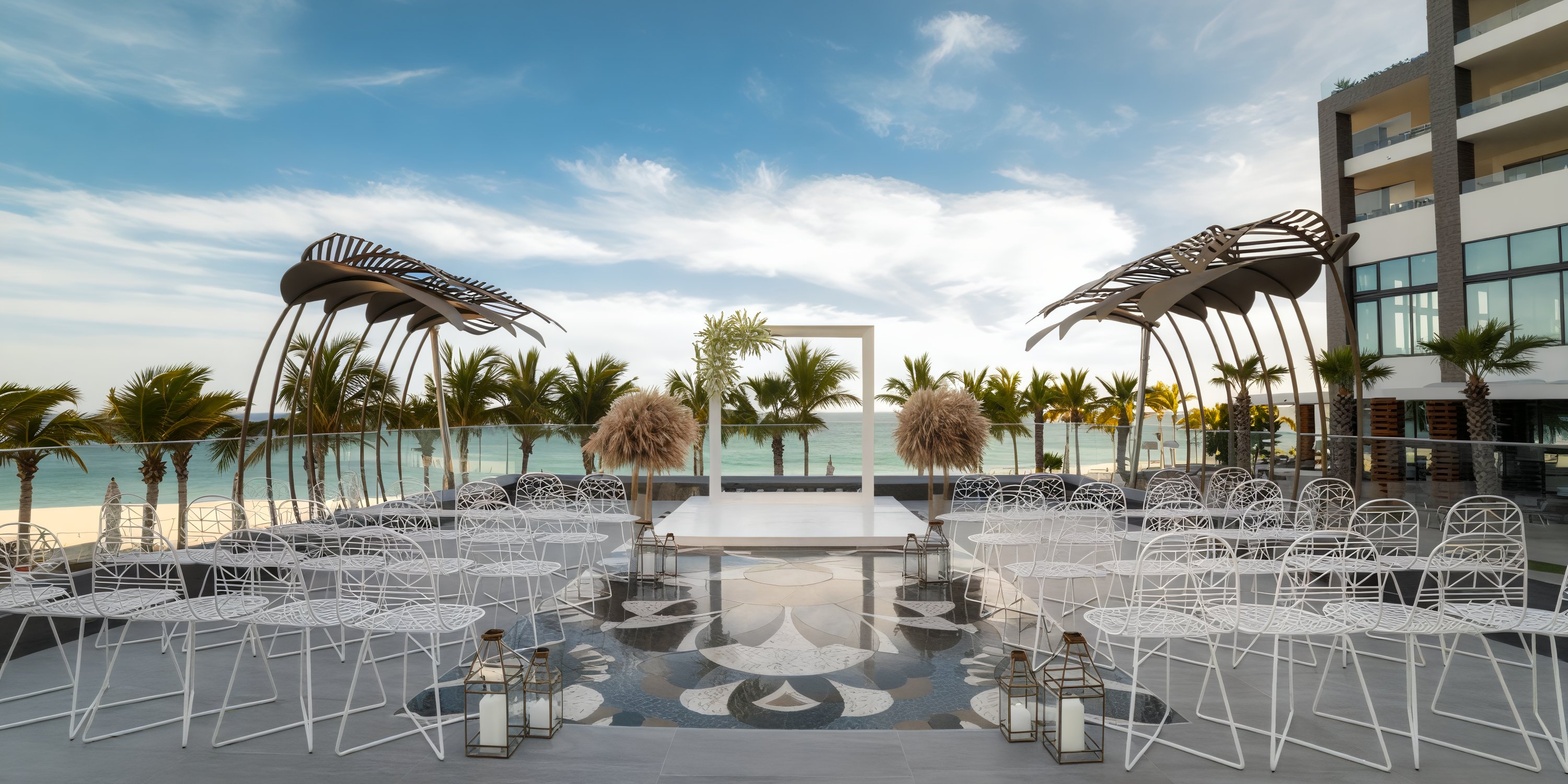Garza Blanca Los Cabos offers a stunning ocean view setting for your destination wedding, featuring elegant white chairs and beautifully crafted decorative arches.