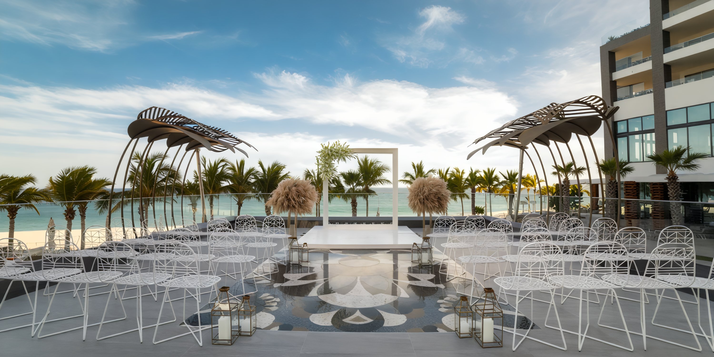 Experience an unforgettable destination wedding at Garza Blanca Los Cabos, featuring stunning ocean views, a beautifully designed stage, elegant white chairs, and enchanting decorative arches.