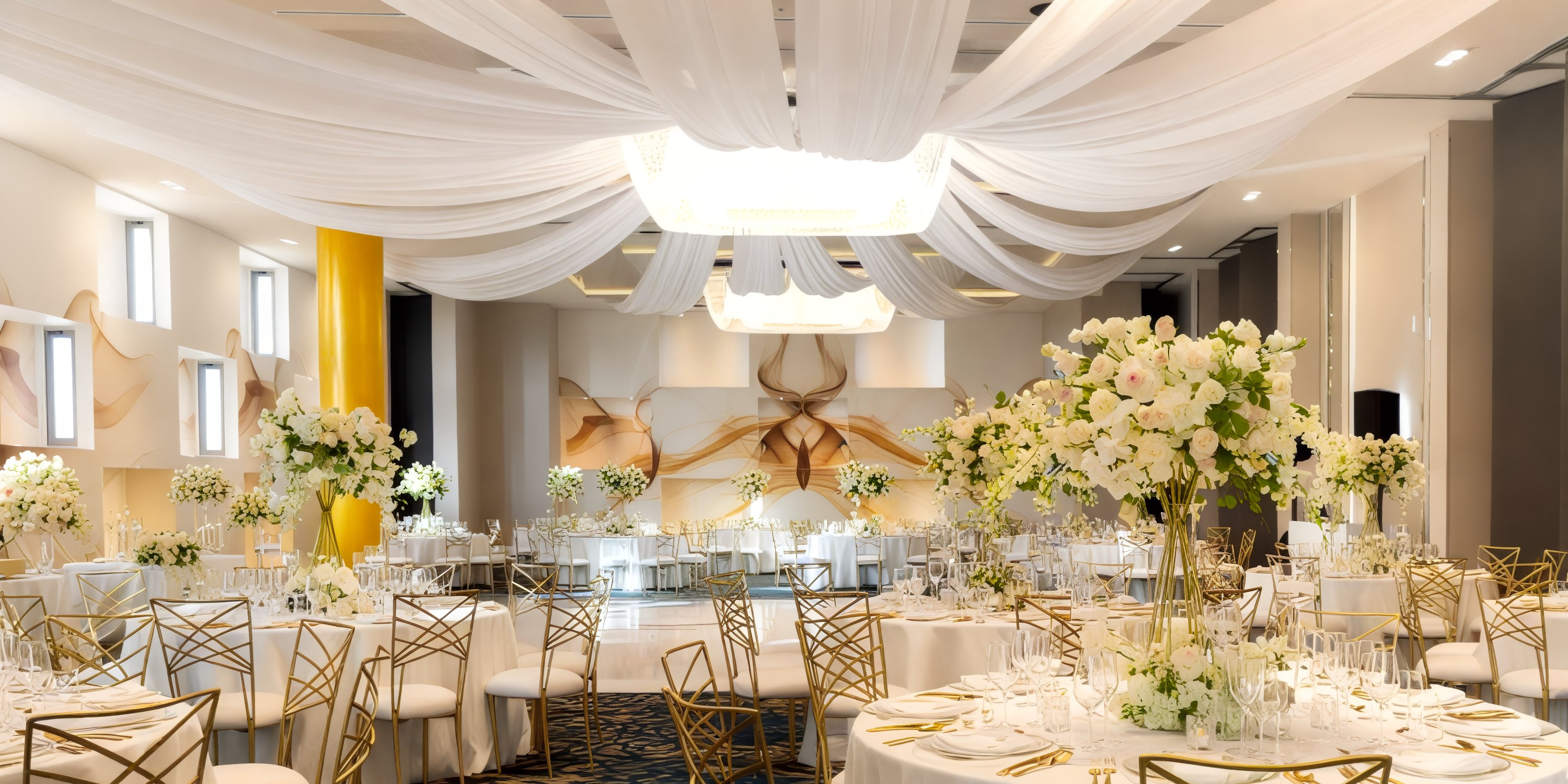 Elegant destination wedding at Garza Blanca Los Cabos featuring a chic white-gold decor, stunning floral centerpieces, and a beautifully draped ceiling.