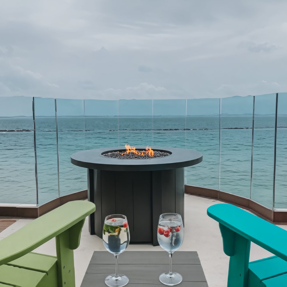 A romantic fire pit on a deck with an ocean view, perfect for a destination wedding, with two chairs and drinks elegantly arranged in the foreground.