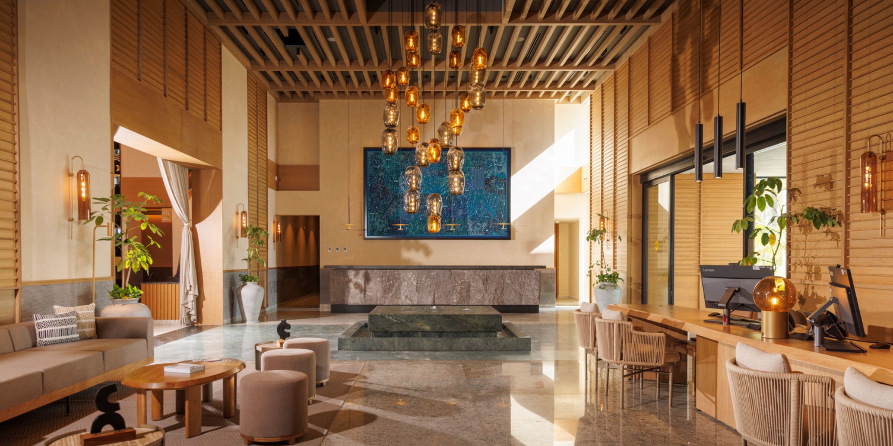 Modern lobby at UNICO 20°105° Riviera Nayarit, ideal for destination wedding guests, with seating and chandelier.