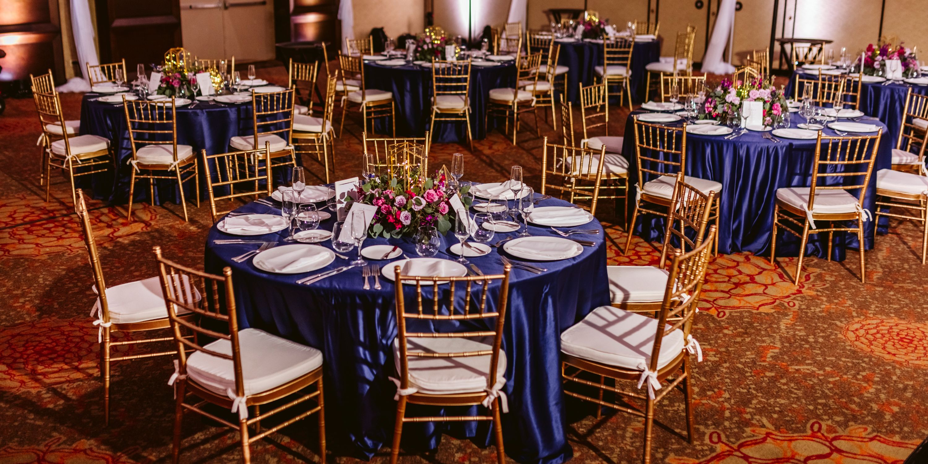 Moon Palace Nizuc banquet hall set for a destination wedding with blue-clothed tables and flowers.