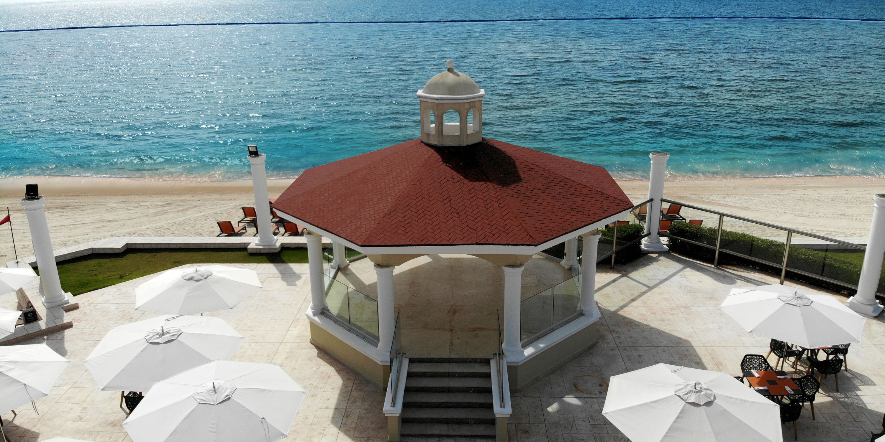 Moon Palace Nizuc offers a perfect destination wedding spot with a white gazebo by the sandy beach and ocean.