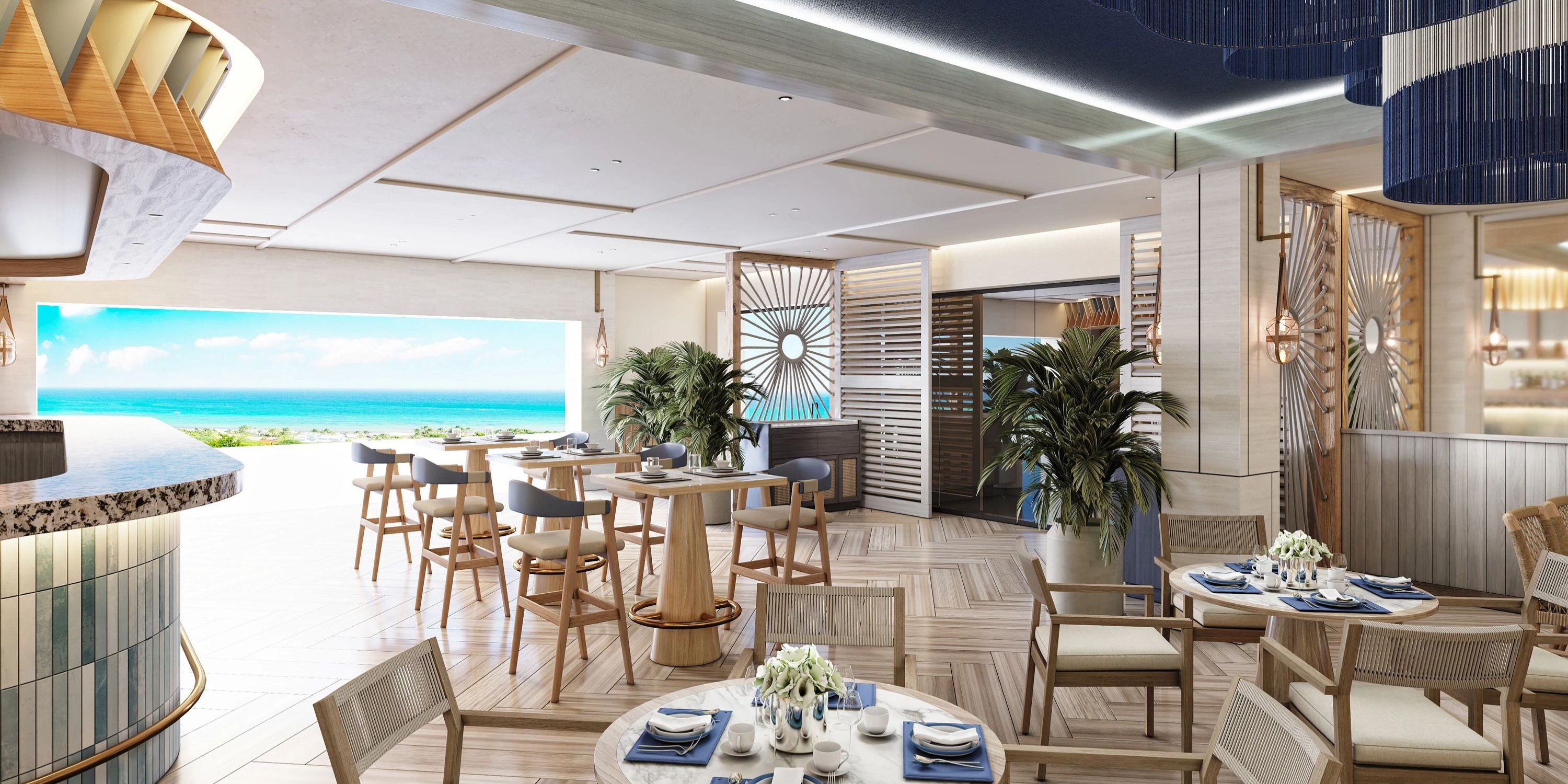 A room set for a destination wedding, featuring tables, chairs, and an ocean view.