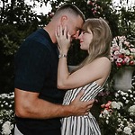 A couple shares a close embrace in a flower-filled garden during their romantic destination wedding.