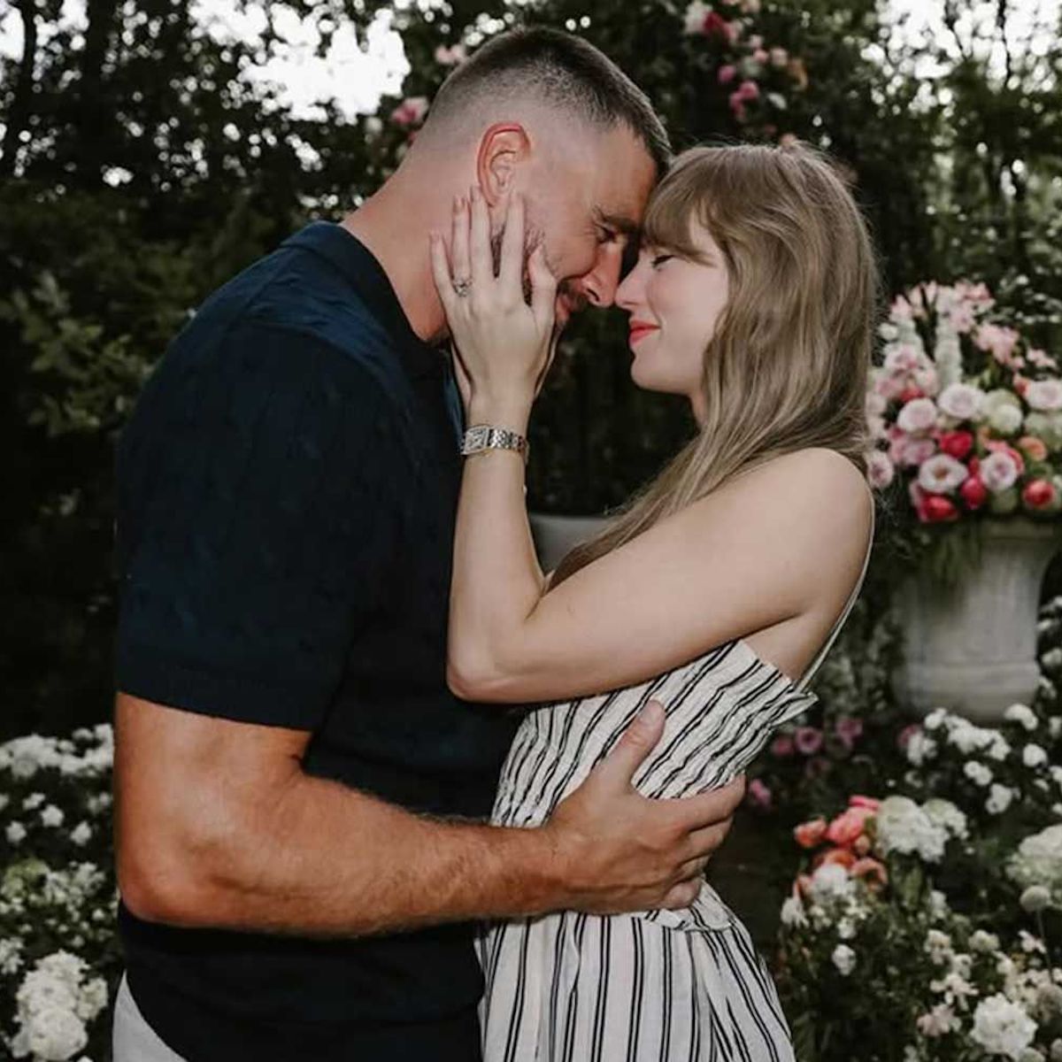 A couple shares a close embrace in a flower-filled garden during their romantic destination wedding.
