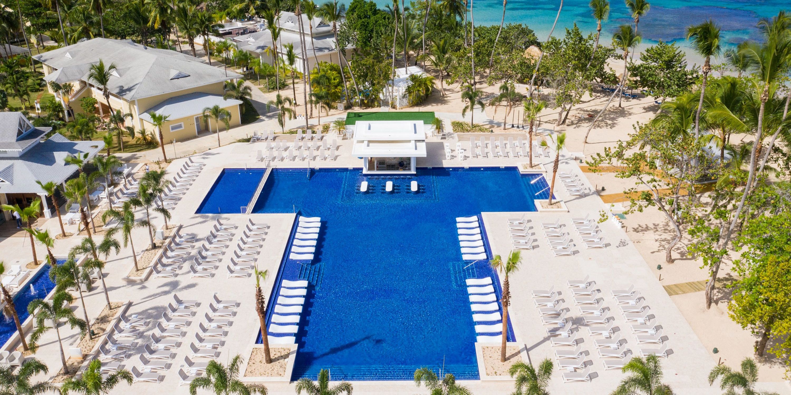 Aerial view of Bahia Principe Grand El Portillo's pool, ideal for a destination wedding, with loungers and palms.