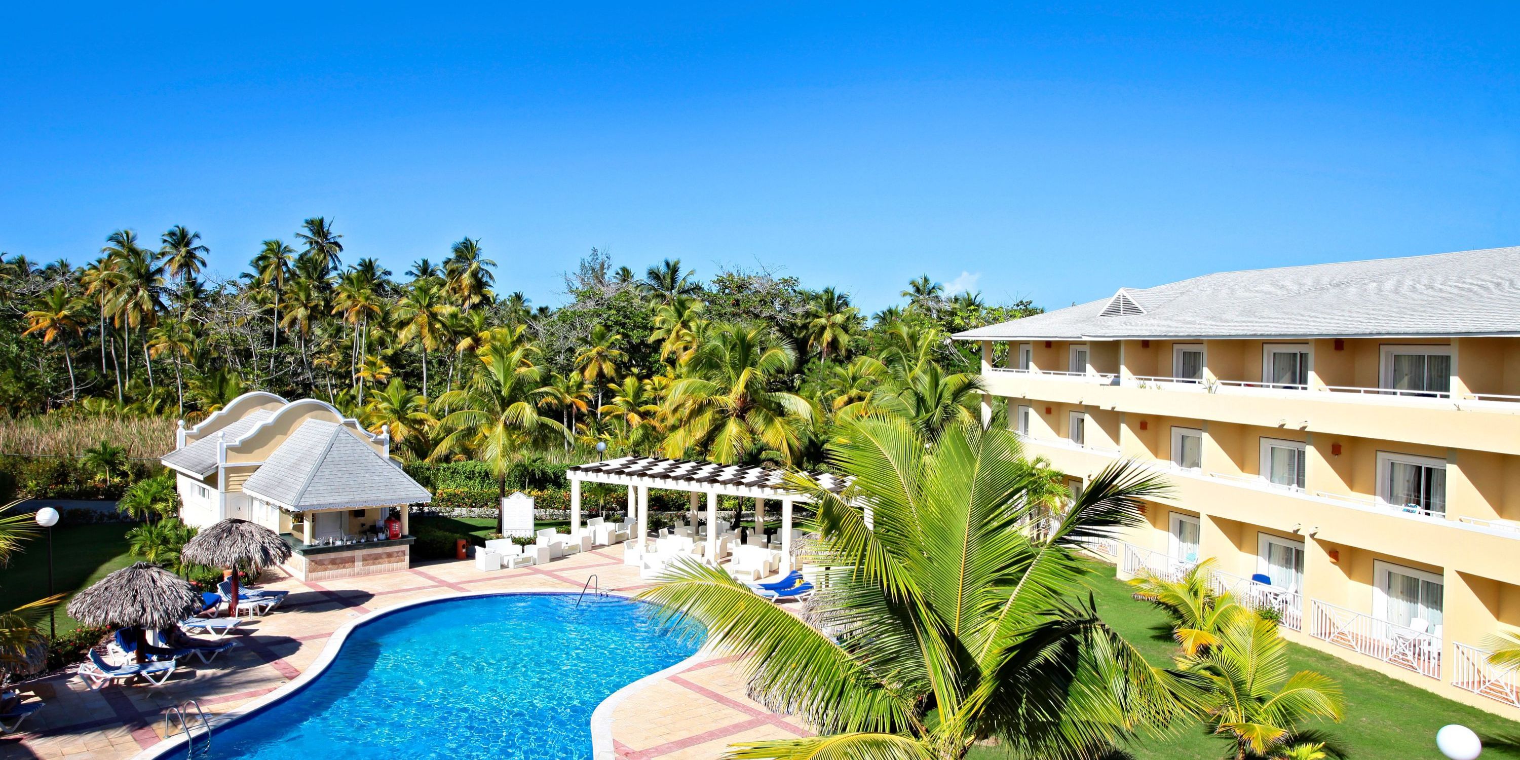 Bahia Principe Grand El Portillo is a stunning destination wedding spot with pool, palms, and hotel views.