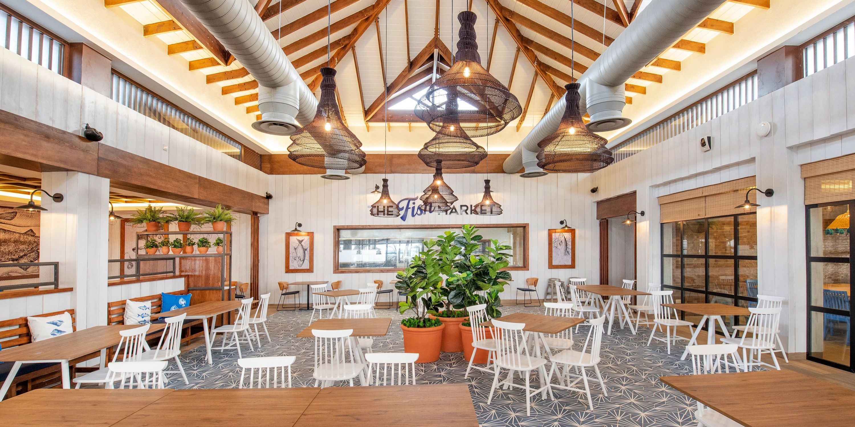 Elegant destination wedding venue at Bahia Principe Grand El Portillo with wooden beams, white chairs, and lush plants.