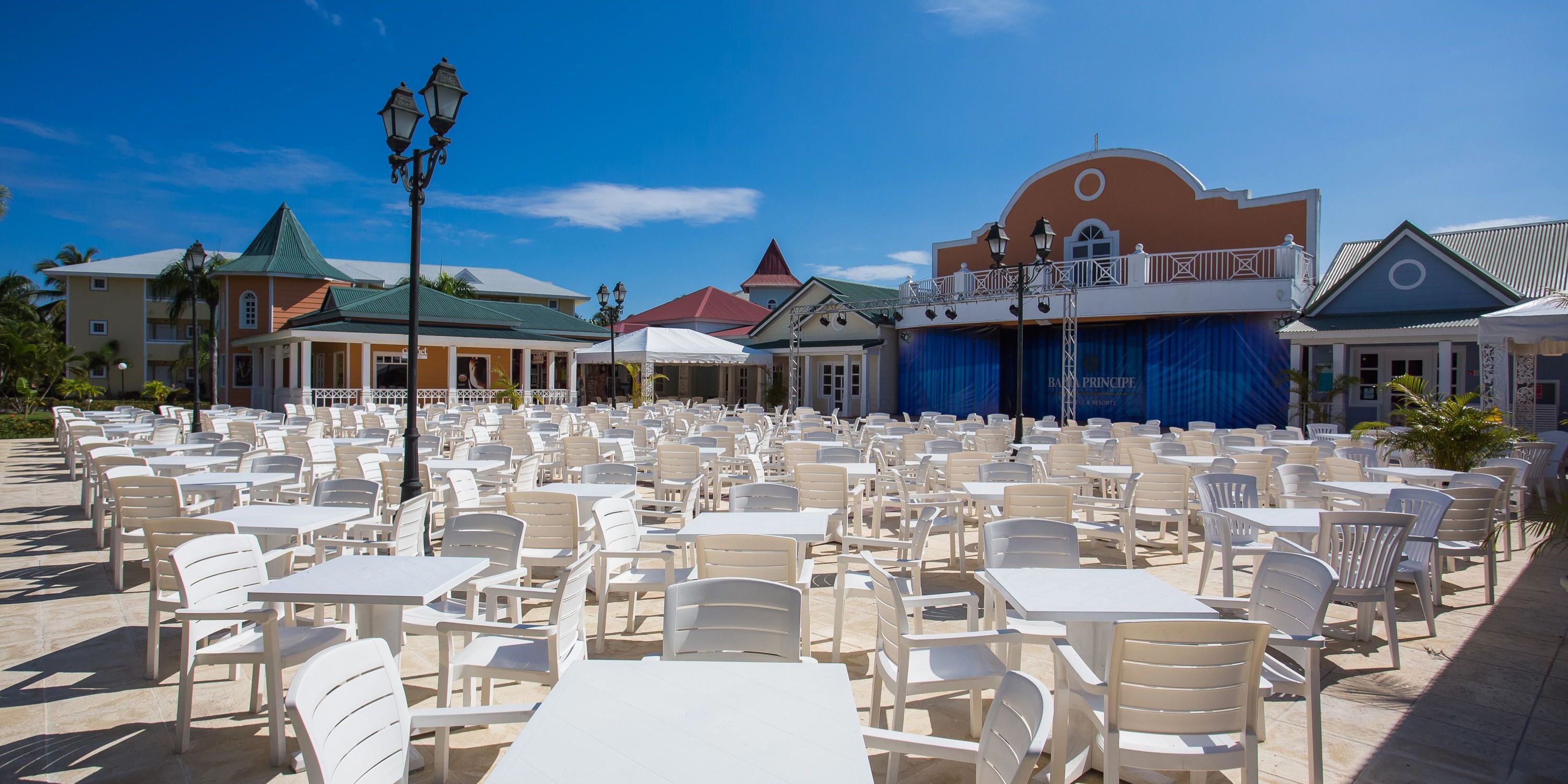 Bahia Principe Grand El Portillo's patio, perfect for a destination wedding, has white tables and a stage.