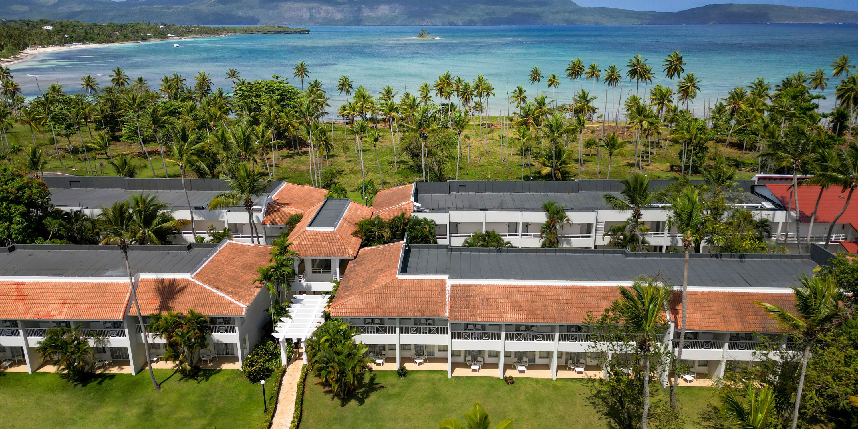 Aerial view of Wyndham Alltra Punta Cana, an ideal destination wedding spot with red roofs, palms, ocean.